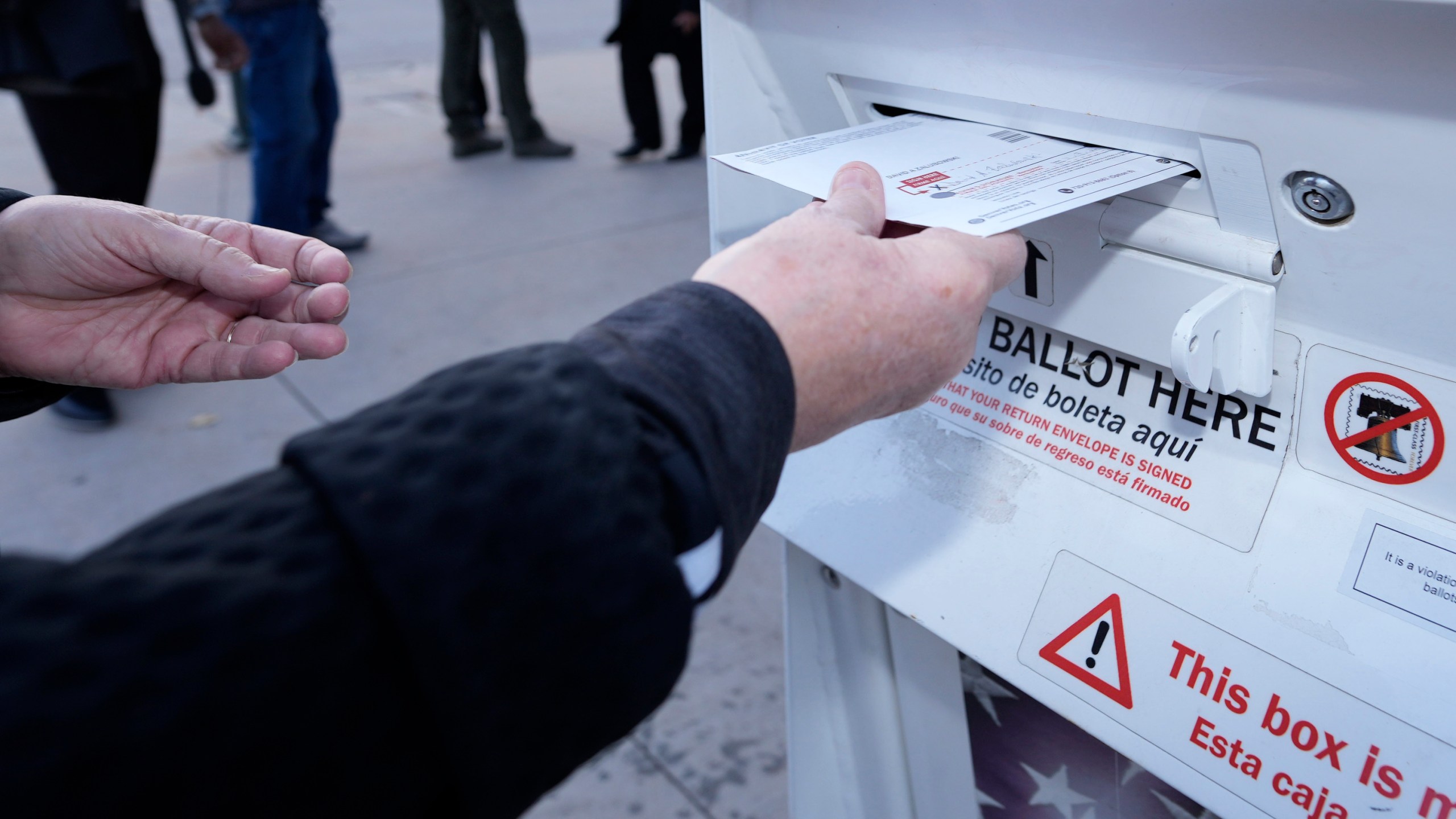 FILE - A voter places a ballot in a drop box outside the Denver Elections Division headquarters Nov. 8, 2022, in downtown Denver. The nation's cybersecurity agency is launching a program aimed at boosting election security in the states, shoring up support for local offices and hoping to provide reassurance to voters that this year's presidential elections will be safe and accurate. (AP Photo/David Zalubowski, File)