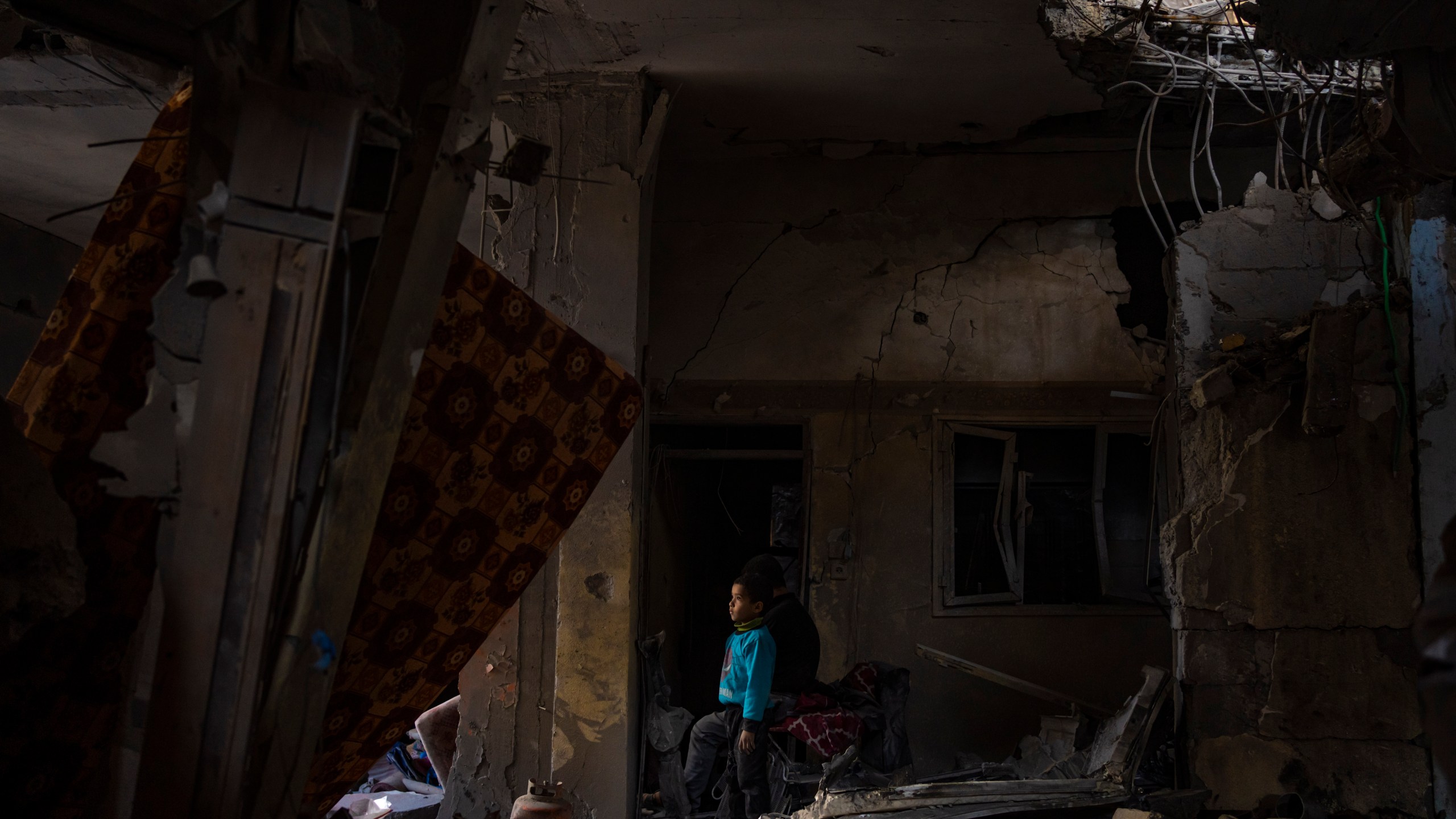 A Palestinian child looks at the damage to his family's house after an Israeli strike in Rafah, southern Gaza Strip, Thursday, Feb. 8, 2024. (AP Photo/Fatima Shbair)