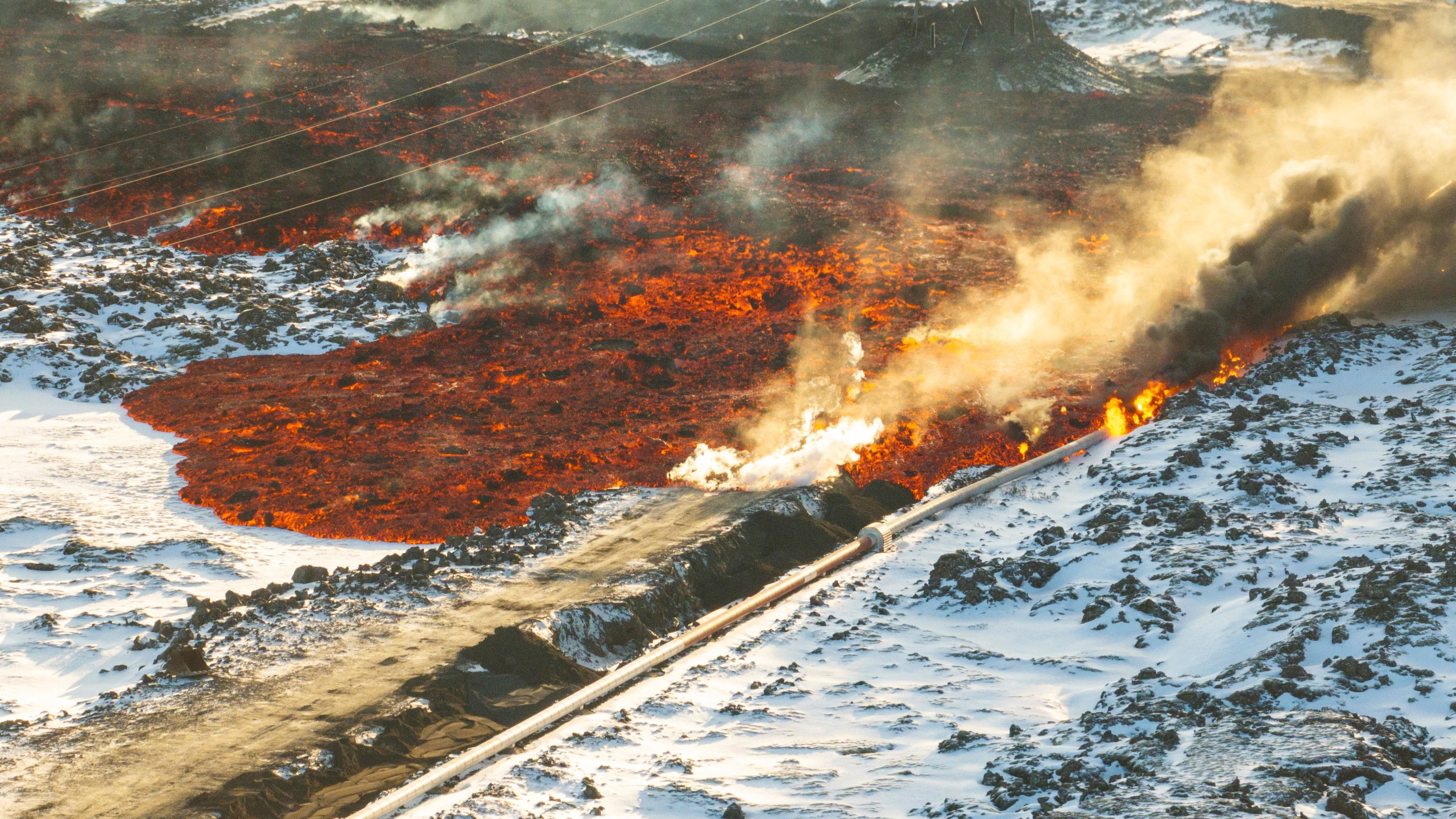 A view of lava hitting the hot water pipeline flowing on the road leading to the Blue Lagoon, in Grindavík, Iceland, Thursday, Feb. 8, 2024. A volcano in southwestern Iceland has erupted for the third time since December and sent jets of lava into the sky. The eruption on Thursday morning triggered the evacuation the Blue Lagoon spa which is one of the island nation’s biggest tourist attractions. (AP Photo /Marco Di Marco)