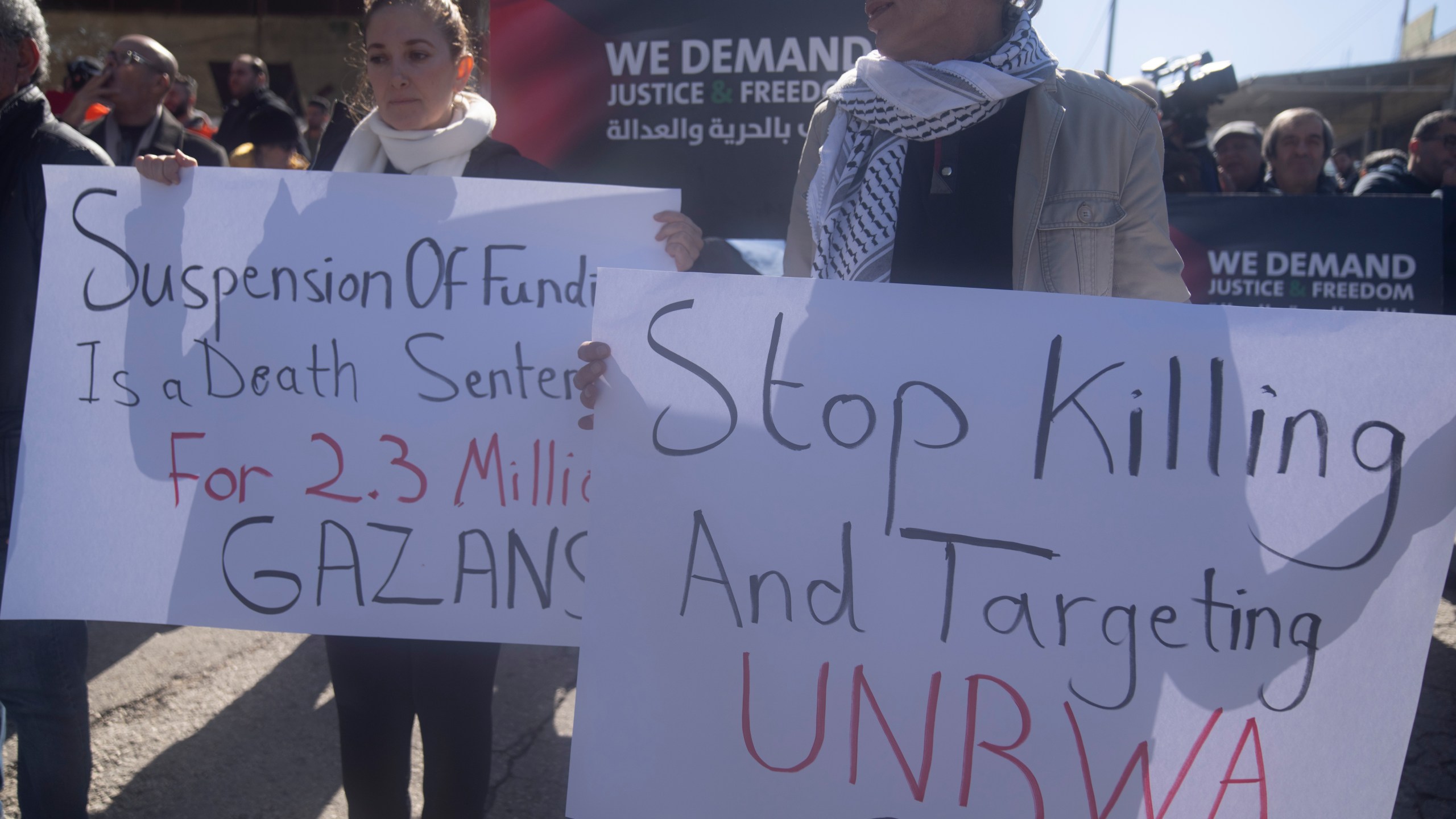 Palestinians protest against the suspension of funds from several donor countries to the United Nations Relief and Works Agency for Palestine Refugees, UNRWA, in front of Agency's offices in the West Bank city of Beitunia Wednesday, Feb. 7, 2024. Several countries suspended funding worth some $440 million, almost half of the UNRWA's annual budget following Israeli allegations that 12 UNRWA employees participated in the Oct. 7 Hamas attacks. (AP Photo/Nasser Nasser)