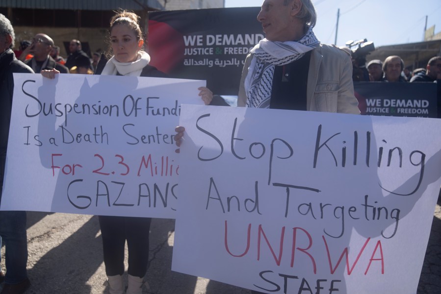 Palestinians protest against the suspension of funds from several donor countries to the United Nations Relief and Works Agency for Palestine Refugees, UNRWA, in front of Agency's offices in the West Bank city of Beitunia Wednesday, Feb. 7, 2024. Several countries suspended funding worth some $440 million, almost half of the UNRWA's annual budget following Israeli allegations that 12 UNRWA employees participated in the Oct. 7 Hamas attacks. (AP Photo/Nasser Nasser)