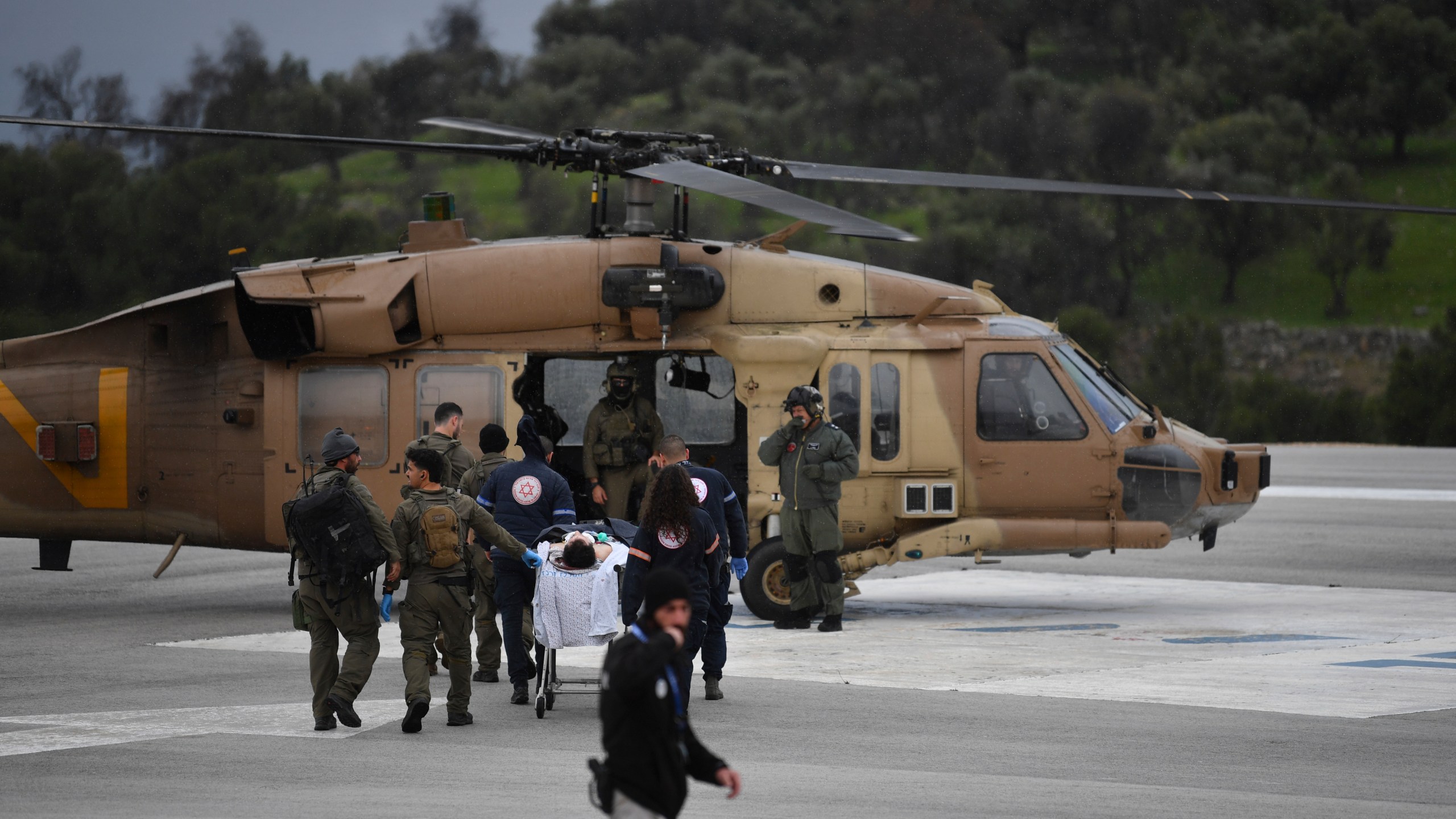 An Israeli medical team evacuate a person injured by a rocket fired from Lebanon, at Ziv hospital in Safed, northern Israel, Wednesday, Feb. 14, 2024. Israeli media reported 1 killed and eight wounded in the rocket attack. The town, which is around 12 kilometers (7 miles) from the border is farther south than most of the daily border skirmishes with Lebanon's Hezbollah militant group. (AP Photo/Gil Eliyahu)