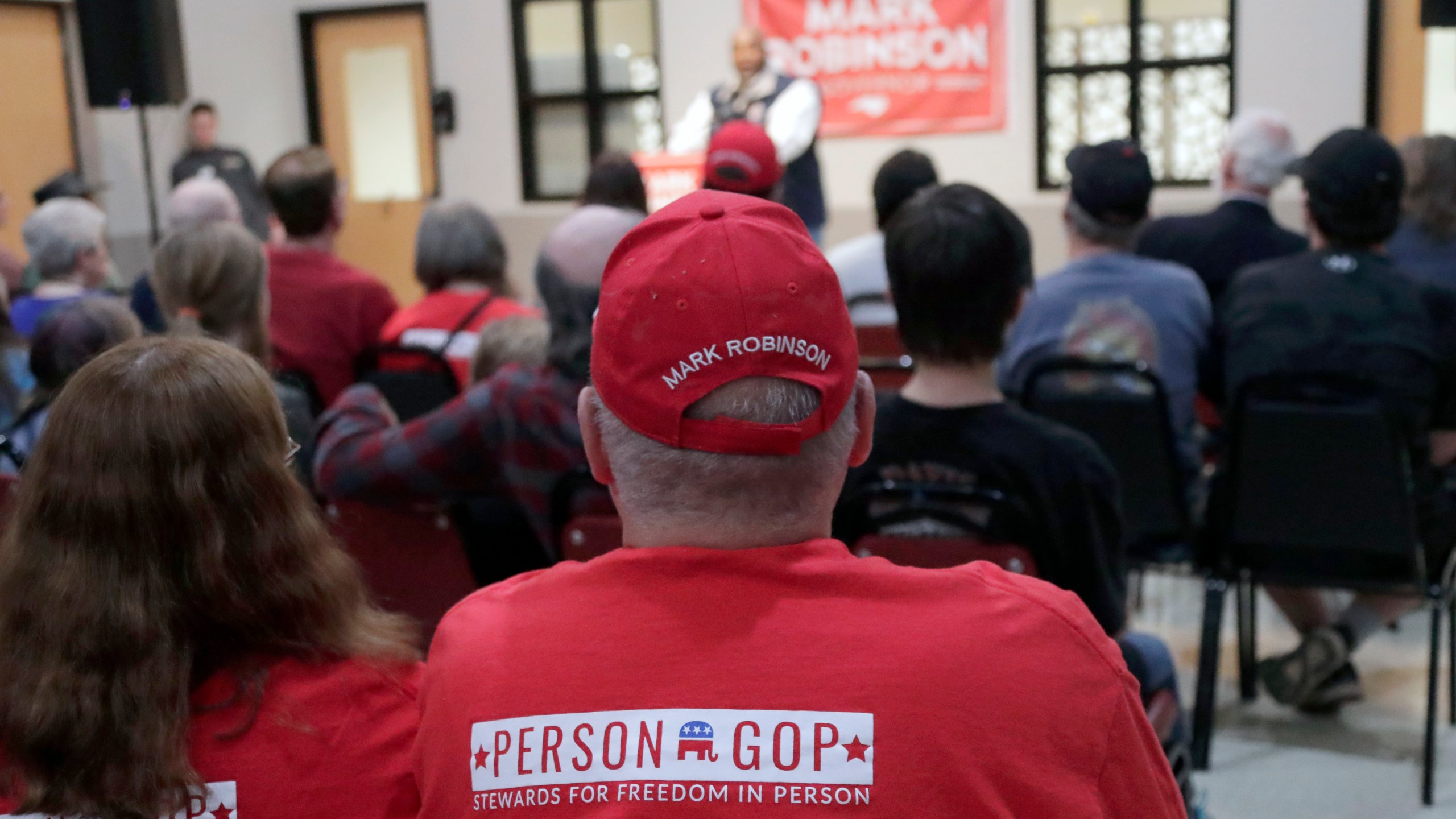 FILE - Attendees listen as North Carolina Lt. Gov. Mark Robinson, a Republican candidate for North Carolina governor, speaks at a rally Friday, Jan. 26, 2024, in Roxboro, N.C. While taking dramatically different paths, Attorney General Josh Stein and Robinson have emerged as frontrunners for their parties' nominations for governor next month in the race to succeed term-limited Democrat Roy Cooper in the nation's ninth largest state. (AP Photo/Chris Seward, File)