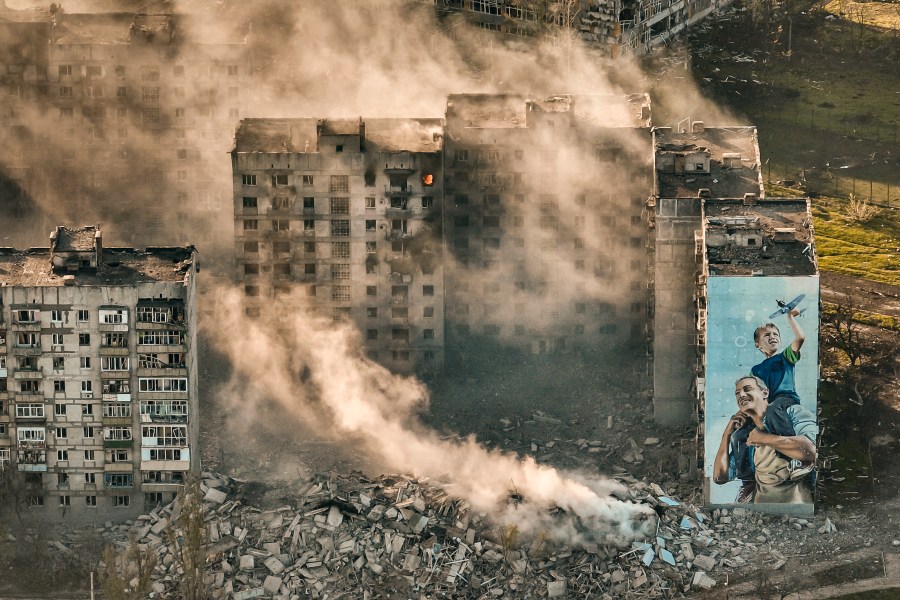 FILE - Smoke rises from a building in Bakhmut, site of the heaviest battles with the Russian troops in the Donetsk region, Ukraine, April 26, 2023. The GOP has been softening its stance on Russia ever since Donald Trump won the 2016 presidential election following Russian hacking of his Democratic opponents. The reasons include Russian President Vladimir Putin holding himself out as an international champion of conservative Christian values, the GOP's growing skepticism of international entanglements and Trump's own personal embrace of the Russian leader. Now the GOP's ambivalence on Russia has stalled additional aid to Ukraine. (AP Photo/Libkos, File)