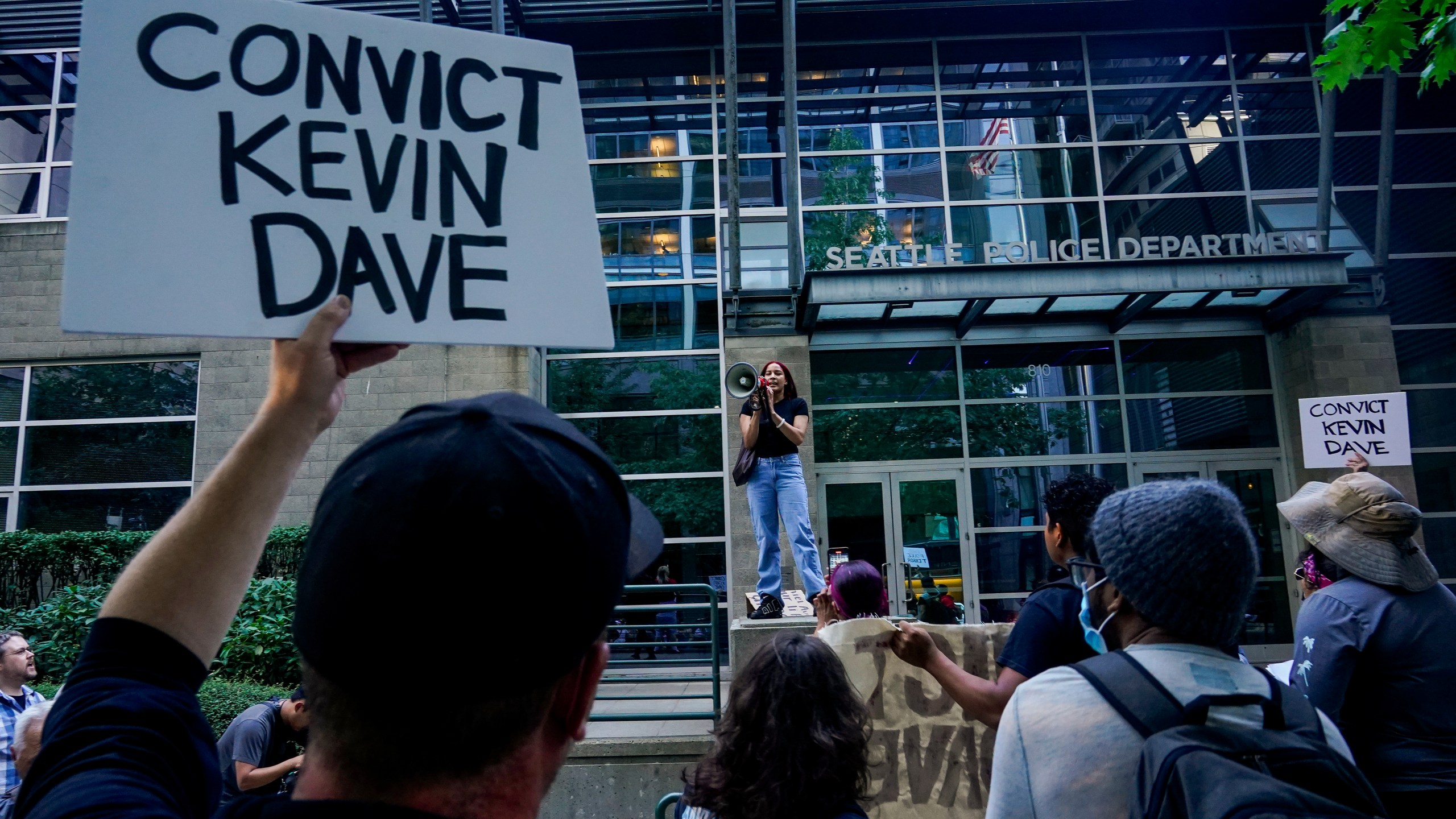 FILE - Kyla Carrillo, center, leads a chant on the steps of the Seattle Police Department's West Precinct as people protest after body camera footage was released of a Seattle police officer joking about the death of Jaahnavi Kandula, a 23-year-old woman hit and killed in January by officer Kevin Dave in a police cruiser, Thursday, Sept. 14, 2023, in Seattle. Prosecutors in Washington state said Wednesday, Feb. 21, 2024, they will not file felony charges against Seattle police officer, Dave, who struck and killed the graduate student from India while responding to an overdose call.. (AP Photo/Lindsey Wasson, File)