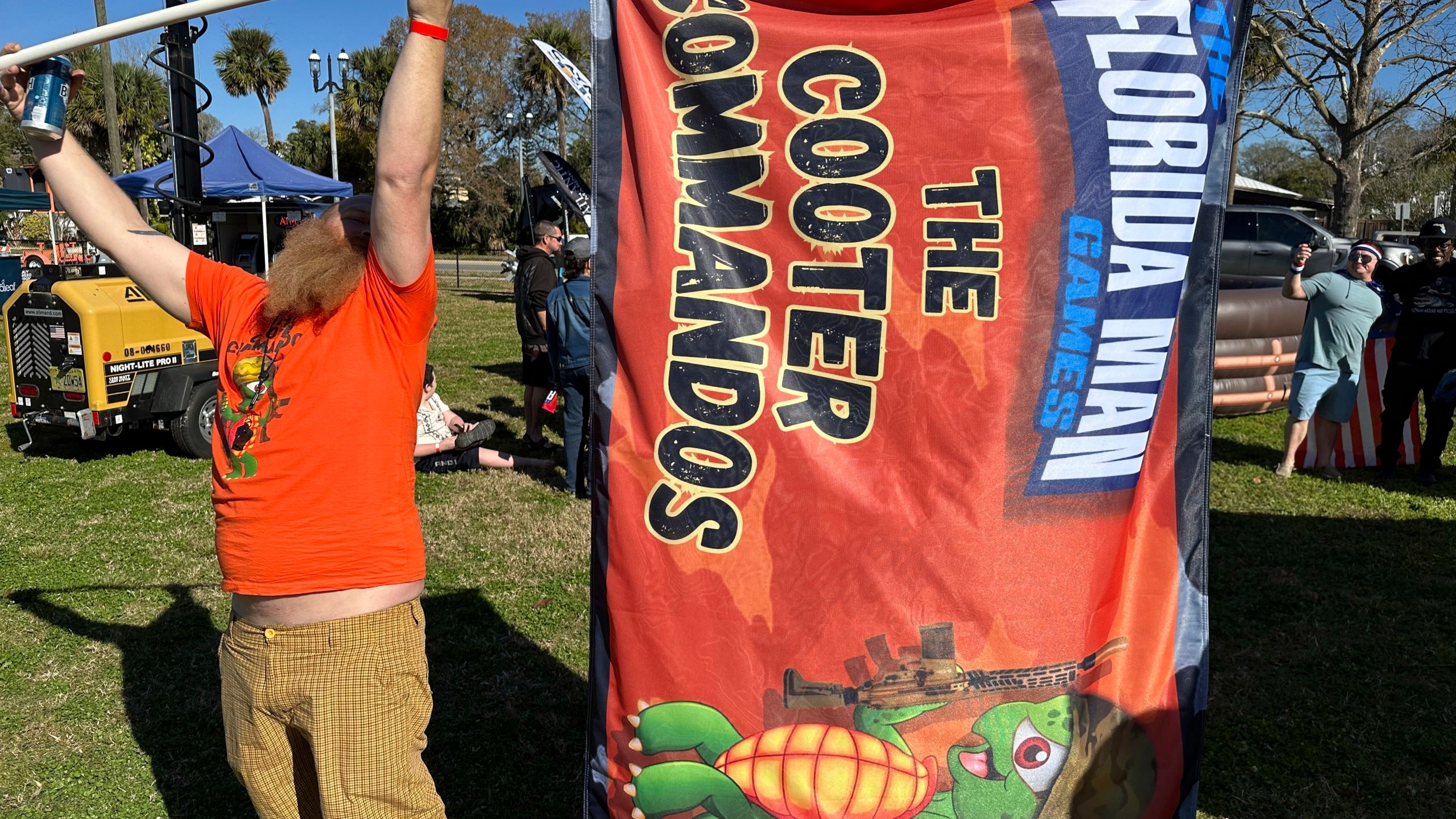 Andrew Peterson waves a flag for the team Cooter Commandos at the Florida Man Games on Saturday, Feb. 24, 2024, in St. Augustine, Fla. (AP Photo/Russ Bynum)