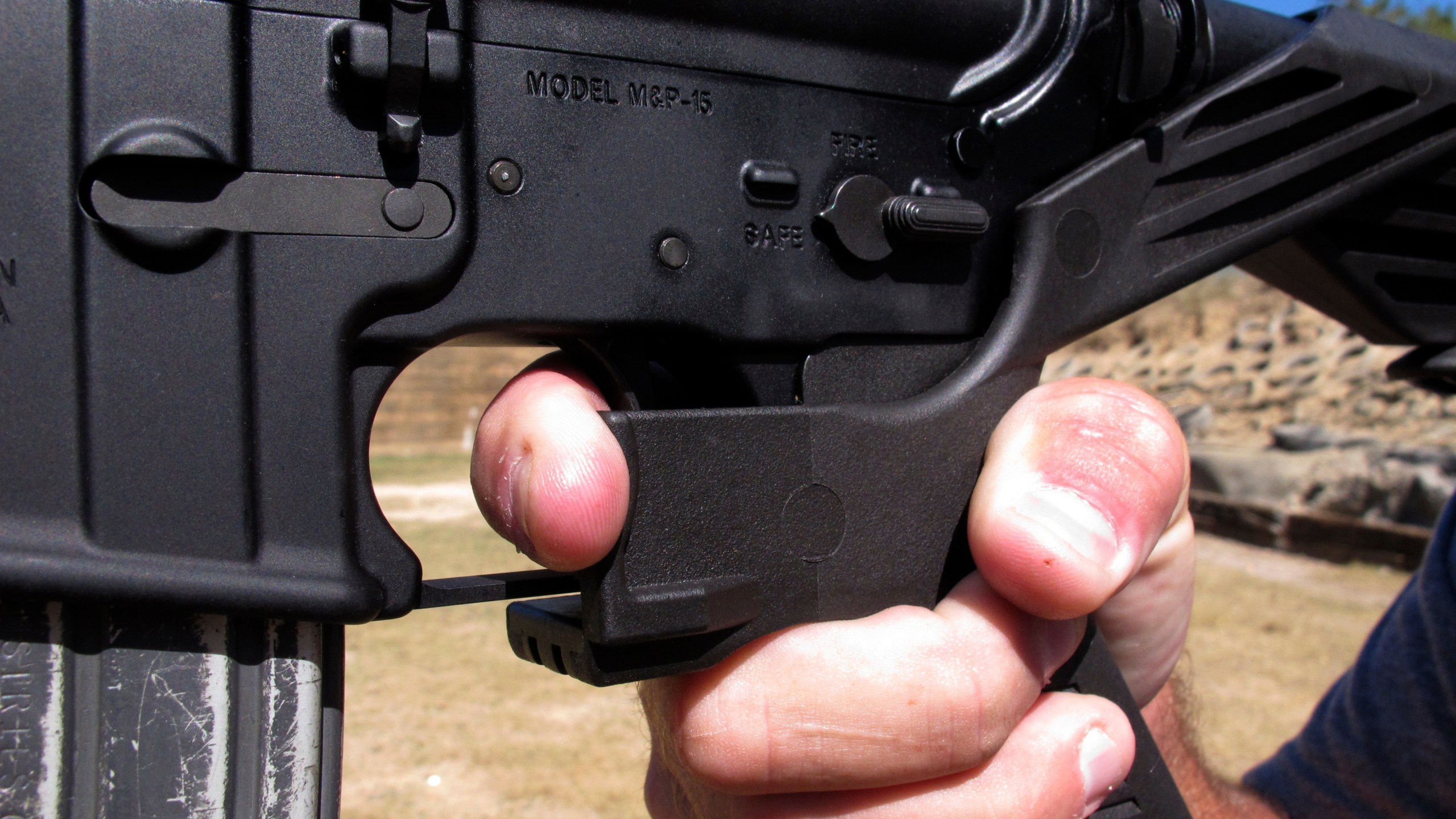 FILE - Shooting instructor Frankie McRae demonstrates the grip on an AR-15 rifle fitted with a "bump stock" at his 37 PSR Gun Club in Bunnlevel, N.C., on Oct. 4, 2017. Gun accessories known as bump stocks hit the market more than a decade ago. The U.S. government initially concluded that the devices that make semi-automatic weapons fire faster didn't violate a federal ban on machine guns. That changed after a gunman with bump stock-equipped rifles killed 60 people and wounded hundreds in Las Vegas in 2017. (AP Photo/Allen G. Breed, File)