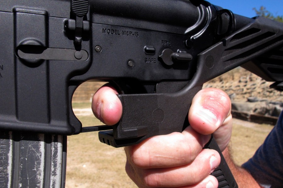 FILE - Shooting instructor Frankie McRae demonstrates the grip on an AR-15 rifle fitted with a "bump stock" at his 37 PSR Gun Club in Bunnlevel, N.C., on Oct. 4, 2017. Gun accessories known as bump stocks hit the market more than a decade ago. The U.S. government initially concluded that the devices that make semi-automatic weapons fire faster didn't violate a federal ban on machine guns. That changed after a gunman with bump stock-equipped rifles killed 60 people and wounded hundreds in Las Vegas in 2017. (AP Photo/Allen G. Breed, File)