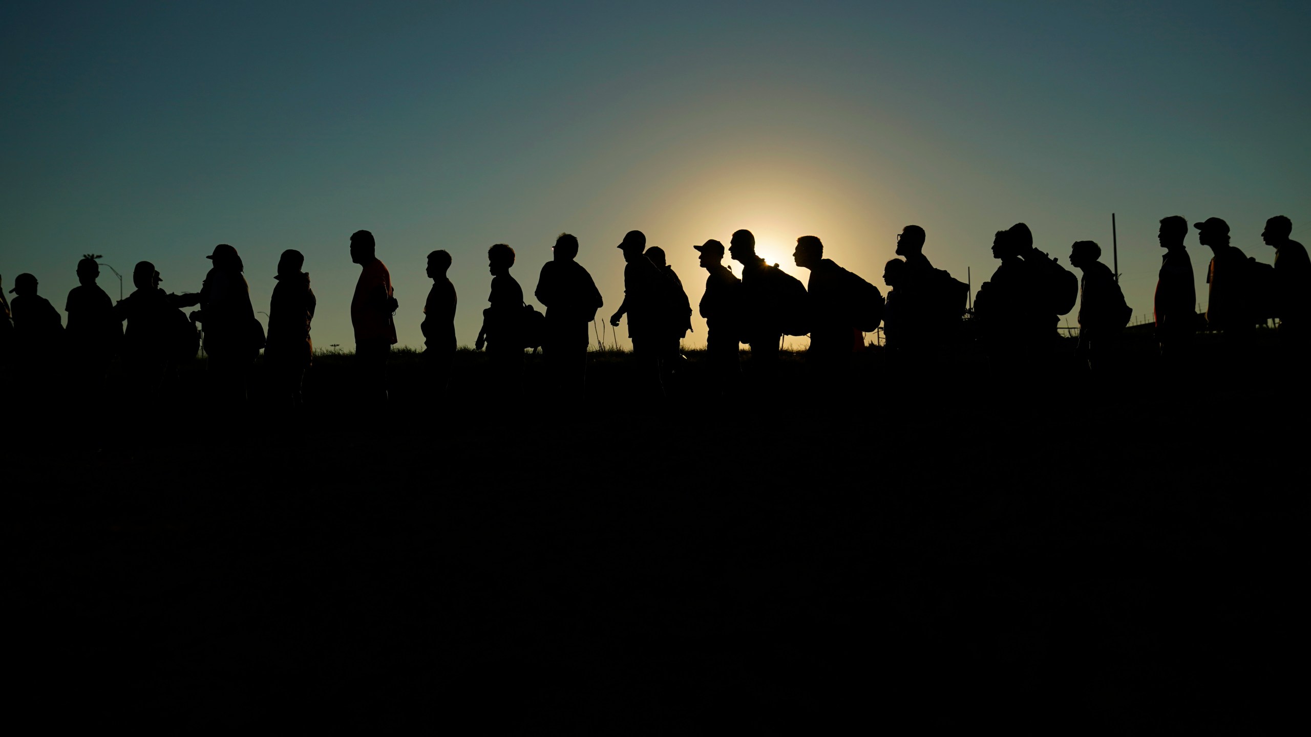 FILE - Migrants who crossed the Rio Grande and entered the U.S. from Mexico are lined up for processing by U.S. Customs and Border Protection, Sept. 23, 2023, in Eagle Pass, Texas. A federal judge on Thursday, Feb. 29, 2024 blocked a new Texas law that gives police broad powers to arrest migrants suspected of illegally entering the U.S., dealing a victory to the Biden administration in its feud with Republican Gov. Greg Abbott over immigration enforcement. (AP Photo/Eric Gay, file)