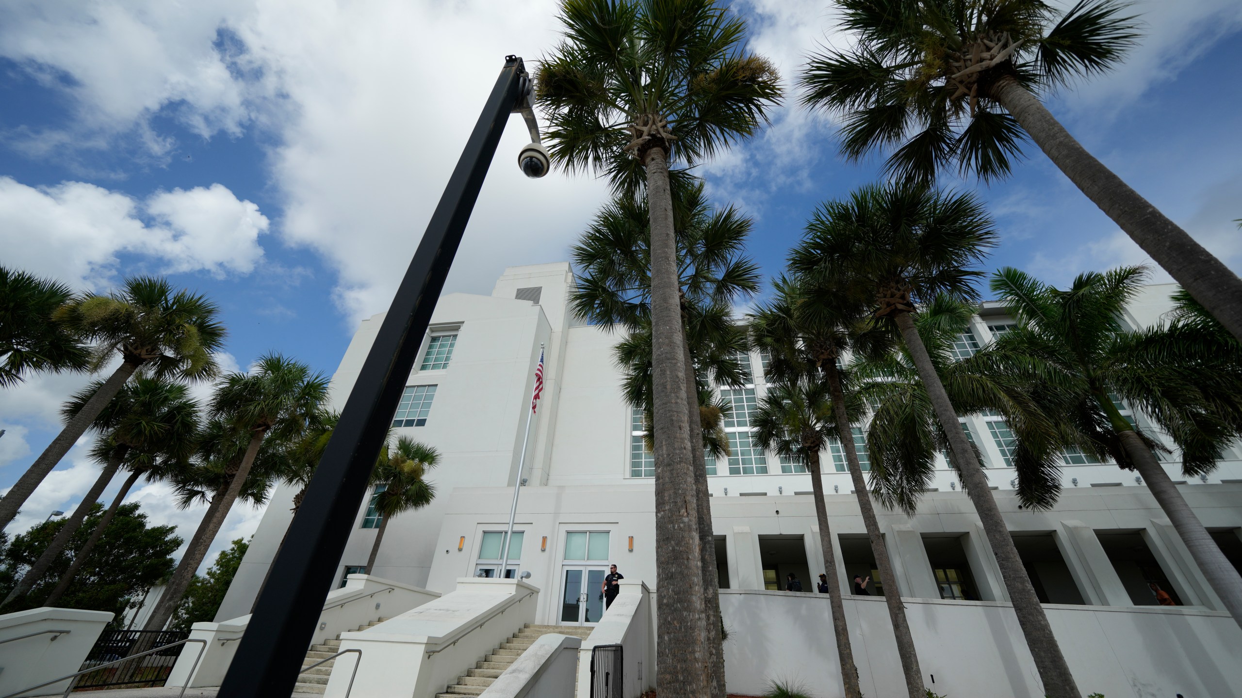 FILE - A police officer stands beside an entrance to the Alto Lee Adams Sr. U.S. Courthouse, Aug. 15, 2023, in Fort Pierce, Fla. The federal judge overseeing the classified documents prosecution of Trump is expected to set a trial date during a court hearing on March 1, 2024. (AP Photo/Rebecca Blackwell, File)