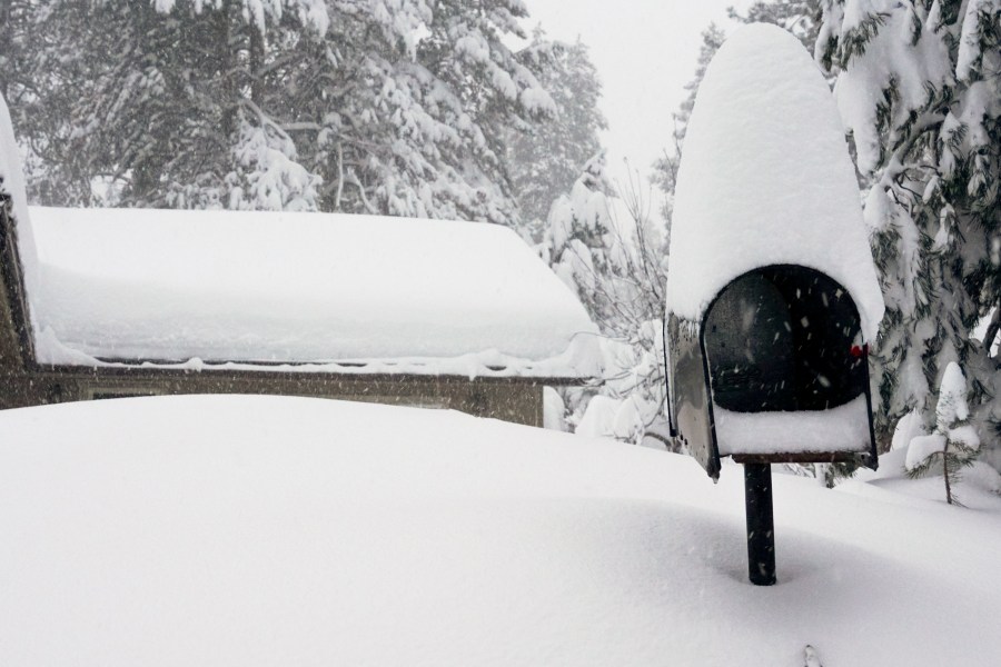 A mailbox and the roof of a home are covered in snow during a storm, Saturday, March 2, 2024, in Truckee, Calif. A powerful blizzard howled Saturday in the Sierra Nevada as the biggest storm of the season shut down a long stretch of Interstate 80 in California and gusty winds and heavy rain hit lower elevations, leaving tens of thousands of homes without power. (AP Photo/Brooke Hess-Homeier)