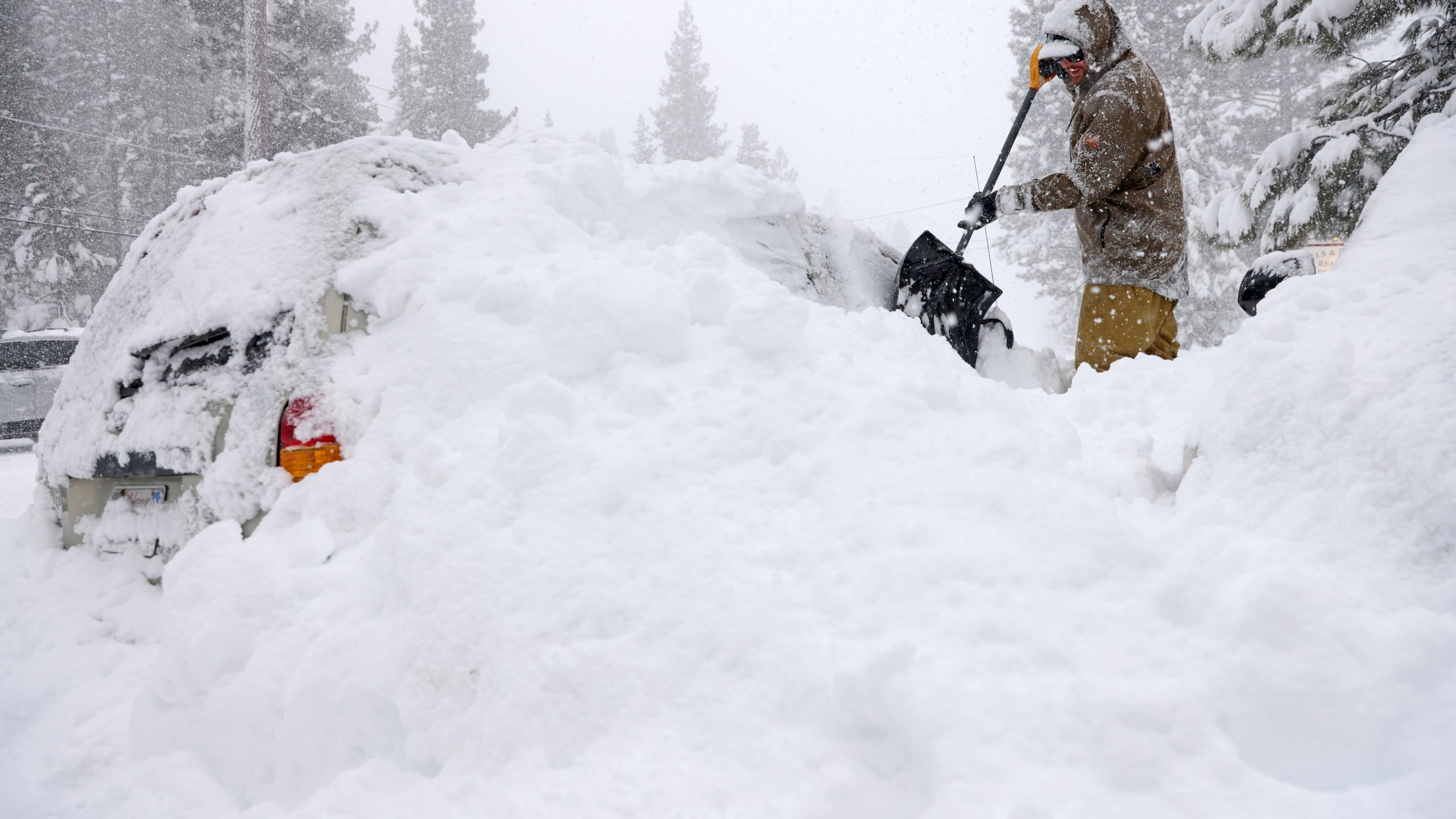 Jake Coleman digs out his car along North Lake Boulevard as snow continues to fall in Tahoe City, Calif., on Saturday, March 2, 2024. (Jane Tyska/Bay Area News Group via AP)