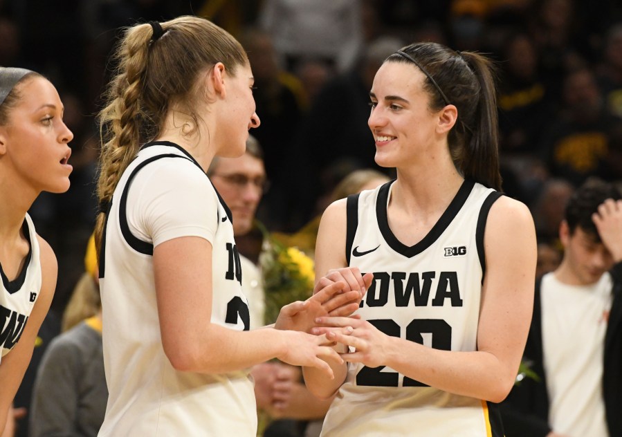 Iowa guards Kate Martin, second from left, greets Iowa guard Caitlin Clark (22) after they were introduced during Senior Day ceremonies following their victory over Ohio State in an NCAA college basketball game, Sunday, March 3, 2024, in Iowa City, Iowa. (AP Photo/Cliff Jette)