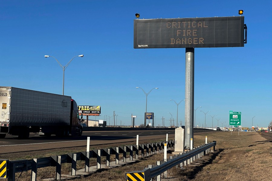 A truck passes a warning sign about the Smokehouse Creek Fire on a highway in Amarillo, Texas on Saturday, March 2, 2024. Firefighters battling the largest wildfire in Texas history face increasingly difficult weather (AP Photo/Ty O'Neil)