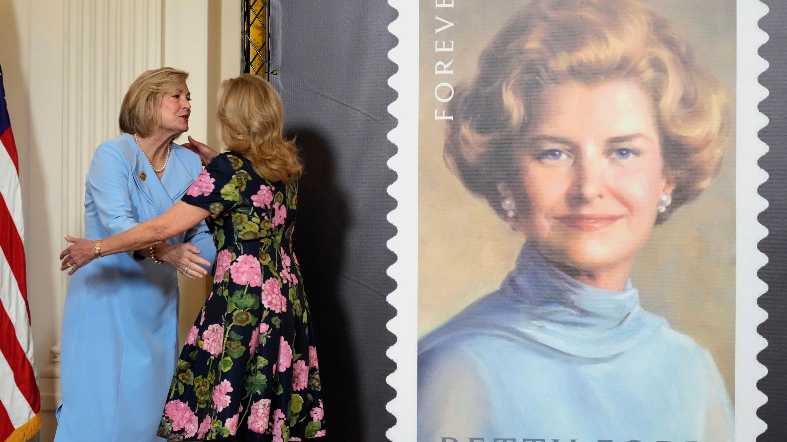 First lady Jill Biden, right, and Susan Ford Bales, left, daughter of former first lady Betty Ford, hug in the East Room of the White House in Washington, Wednesday, March 6, 2024, during an unveiling of a new U.S. Postal Service stamp honoring former first lady Betty Ford. (AP Photo/Susan Walsh)