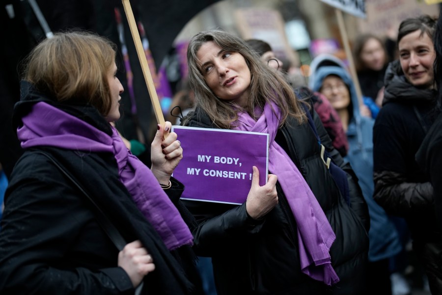 FILE - Women talk during a demonstration as part of the International Women's Day, March 8, 2023 in Paris. Women across the world will demand equal pay, reproductive rights, education, justice and other essential needs during demonstrations marking International Women’s Day on Friday, March 8, 2024. (AP Photo/Christophe Ena, File)