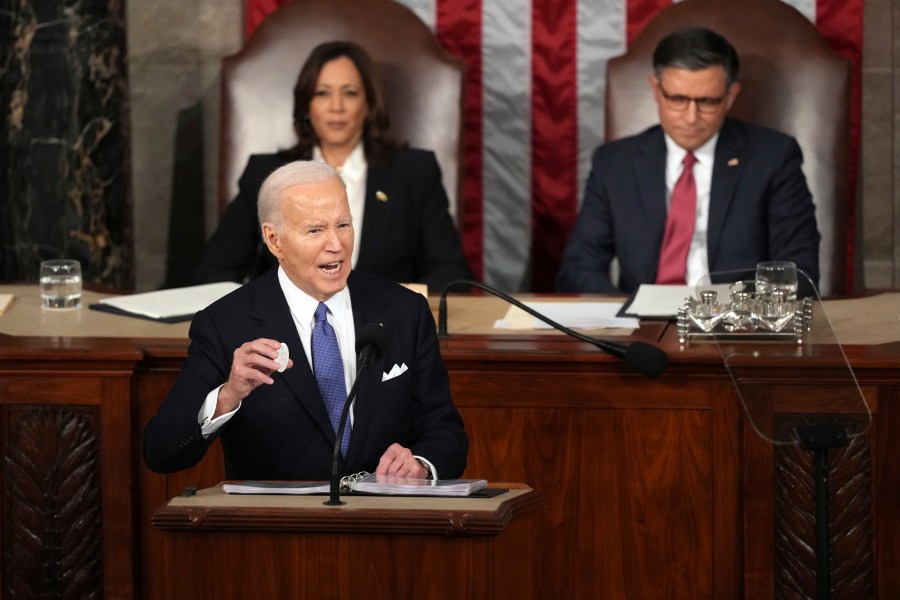 President Joe Biden holds a Laken Riley Botton as delivers the State of the Union address to a joint session of Congress at the U.S. Capitol, Thursday March 7, 2024, in Washington, while Vice President Kamala Harris and House Speaker Mike Johnson of La., watch. (AP Photo/Andrew Harnik)