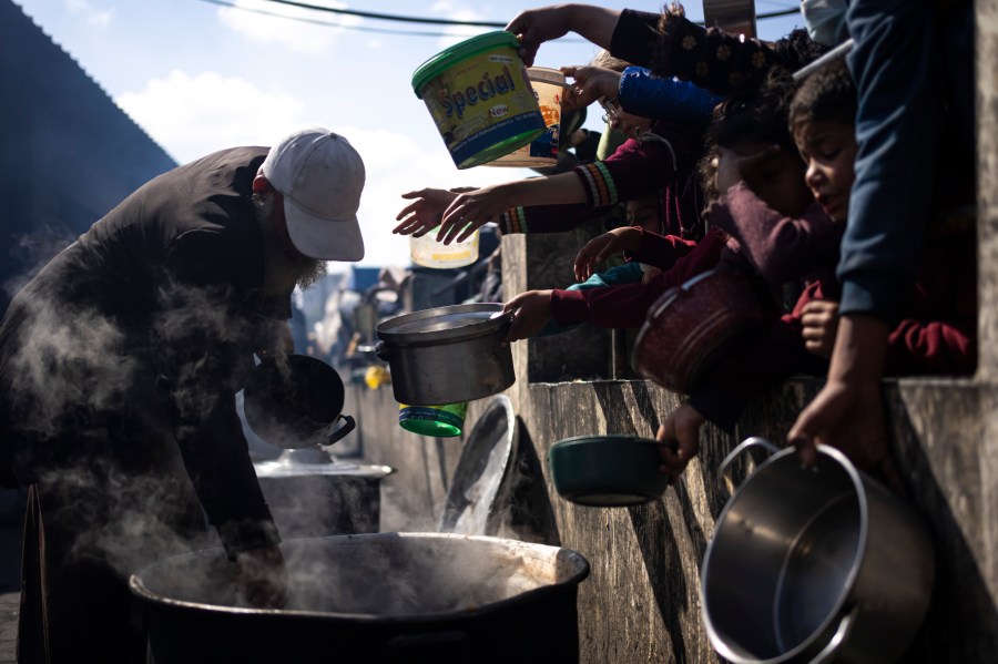 FILE - Palestinians line up for a free meal in Rafah, Gaza Strip, Friday, Feb. 16, 2024. President Joe Biden has proposed the delivery of humanitarian assistance to Gaza via a temporary port on the territory’s Mediterranean coast. (AP Photo/Fatima Shbair, File)