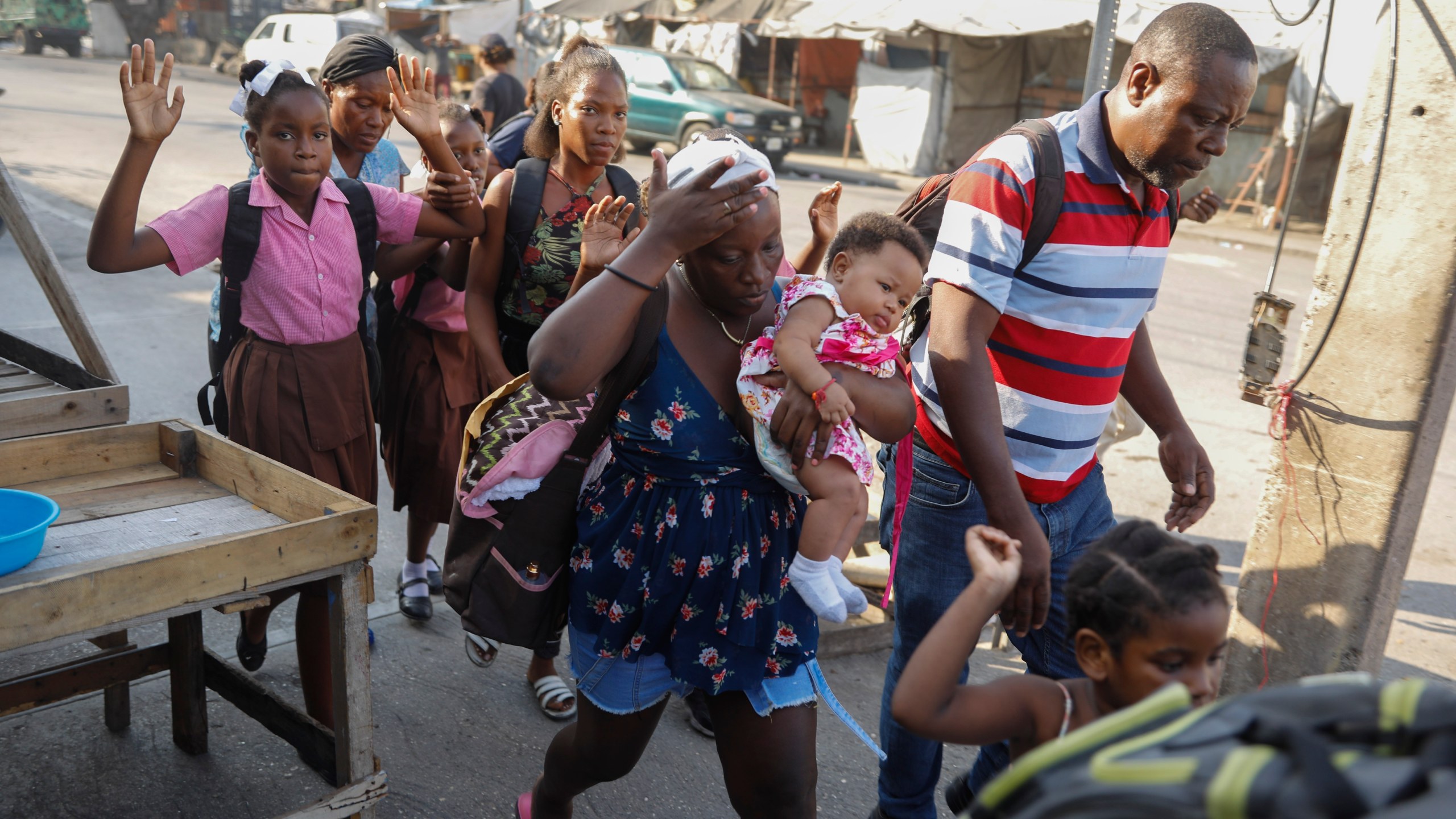 FILE - Residents flee their homes during clashes between police and gang member at the Portail neighborhood in Port-au-Prince, Haiti, Thursday, Feb. 29, 2024. Unrelenting gang attacks in Haiti have paralyzed the country and left it with dwindling supplies of basic goods. Worsening the situation is this week's closure of Port-au-Prince's main seaport. The move left stranded scores of containers filled with critical items like food and medical supplies in a country where U.N. officials say half the population does not have enough to eat and 1.4 million are starving. (AP Photo/Odelyn Joseph, File)