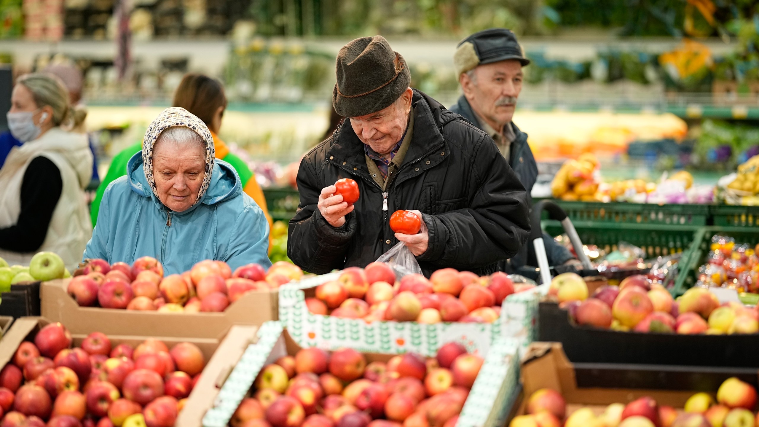 FILE - People buy fruit at a market in Moscow, Russia, on Nov. 3, 2023. The shelves at Moscow supermarkets are full of fruit, vegetables, cheese and meat, but many shoppers look at the selection with dismay as inflation drives up their price. (AP Photo)