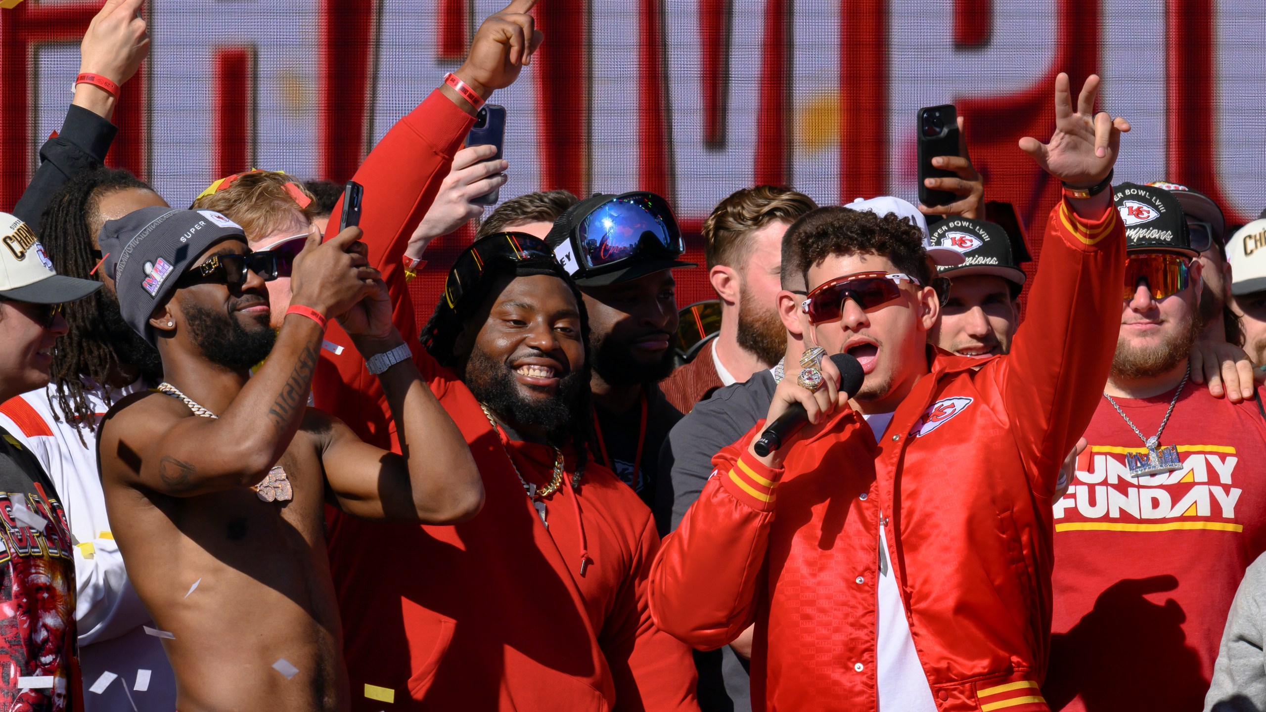 Kansas City Chiefs quarterback Patrick Mahomes, right, tells the crowd the Chiefs want to win another Super Bowl next season, during their victory rally in Kansas City, Mo., Wednesday, Feb. 14, 2024. The Chiefs defeated the San Francisco 49ers Sunday in the NFL Super Bowl 58 football game. (AP Photo/Reed Hoffmann)