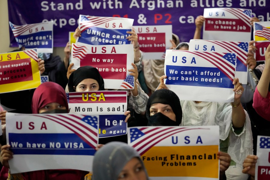 FILE - Afghan refugees hold placards during a gathering in Islamabad, Pakistan, July 21, 2023. Senators from both parties are urging congressional leaders to ensure that more visas are made available to Afghans who worked alongside U.S. troops in America's longest war. The senators say an additional 20,000 visas are needed before the end of the fiscal year in September. (AP Photo/Rahmat Gul, File)