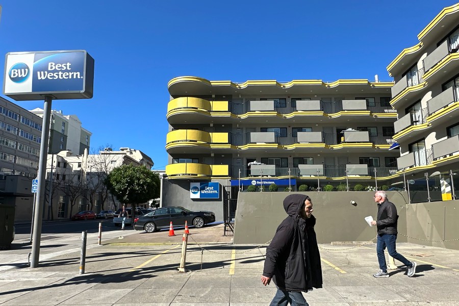 Pedestrians walk in front of a Best Western Red Coach Inn in the Tenderloin neighborhood of San Francisco, Thursday, March 14, 2024. Two hotels and unnamed residents of one of San Francisco's most problematic neighborhoods for drug use and tent encampments sued the city Thursday, demanding that city officials stop using the district as a containment zone. (AP Photo/Jeff Chiu)