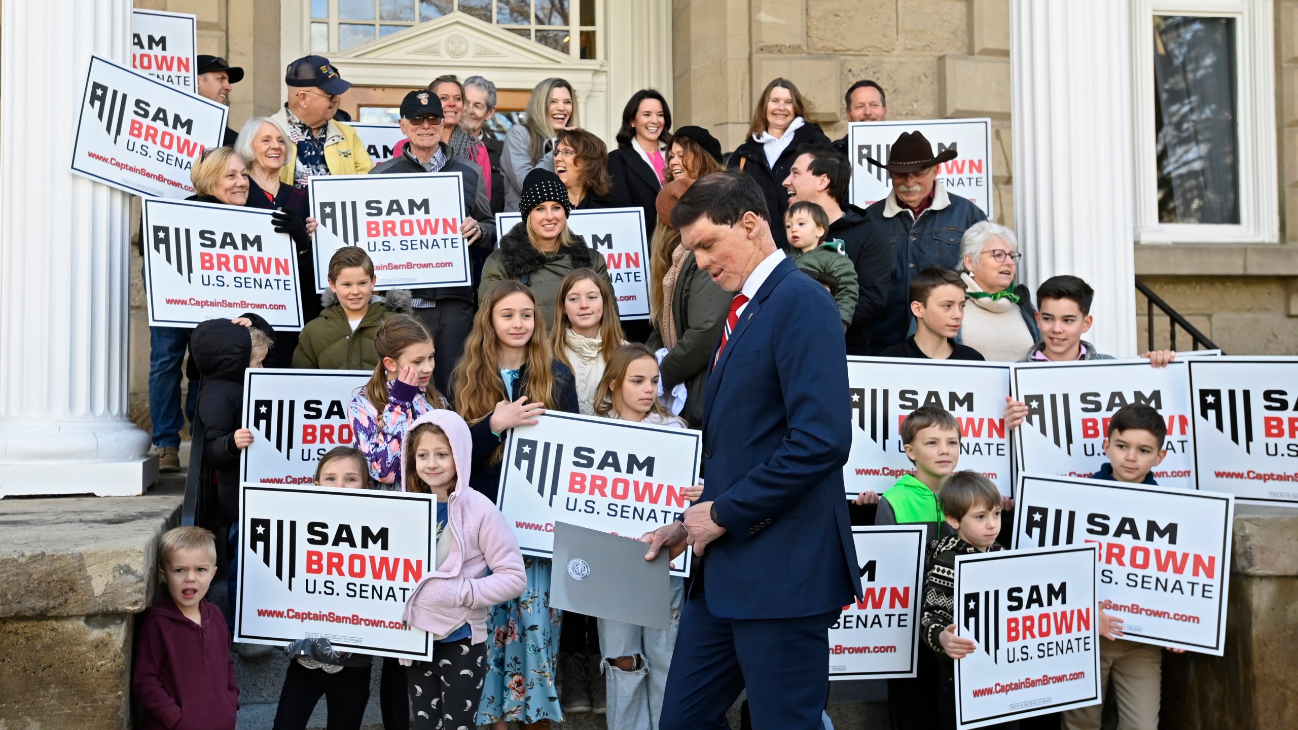 Republican U.S. Senatorial candidate Sam Brown stands next to supporters as he gets ready to speak after filing his paperwork to run for the Senate, Thursday, March 14, 2024, at the State Capitol in Carson City, Nev. Brown is seeking to replace incumbent U.S. Sen. Jacky Rosen. (AP Photo/Andy Barron)