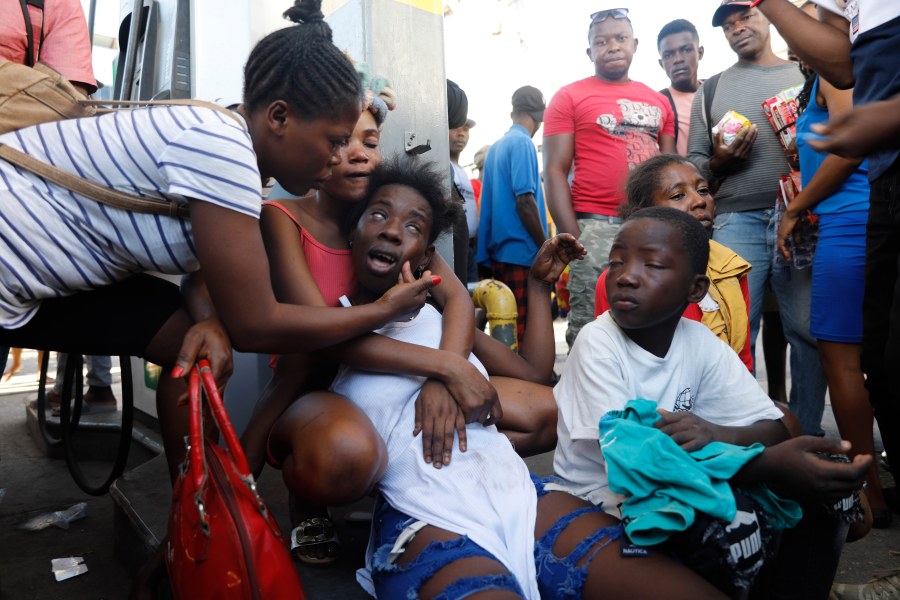 The relative of a person found dead in the street reacts after an overnight shooting in the Petion Ville neighborhood of Port-au-Prince, Haiti, Monday, March 18, 2024. (AP Photo/Odelyn Joseph)