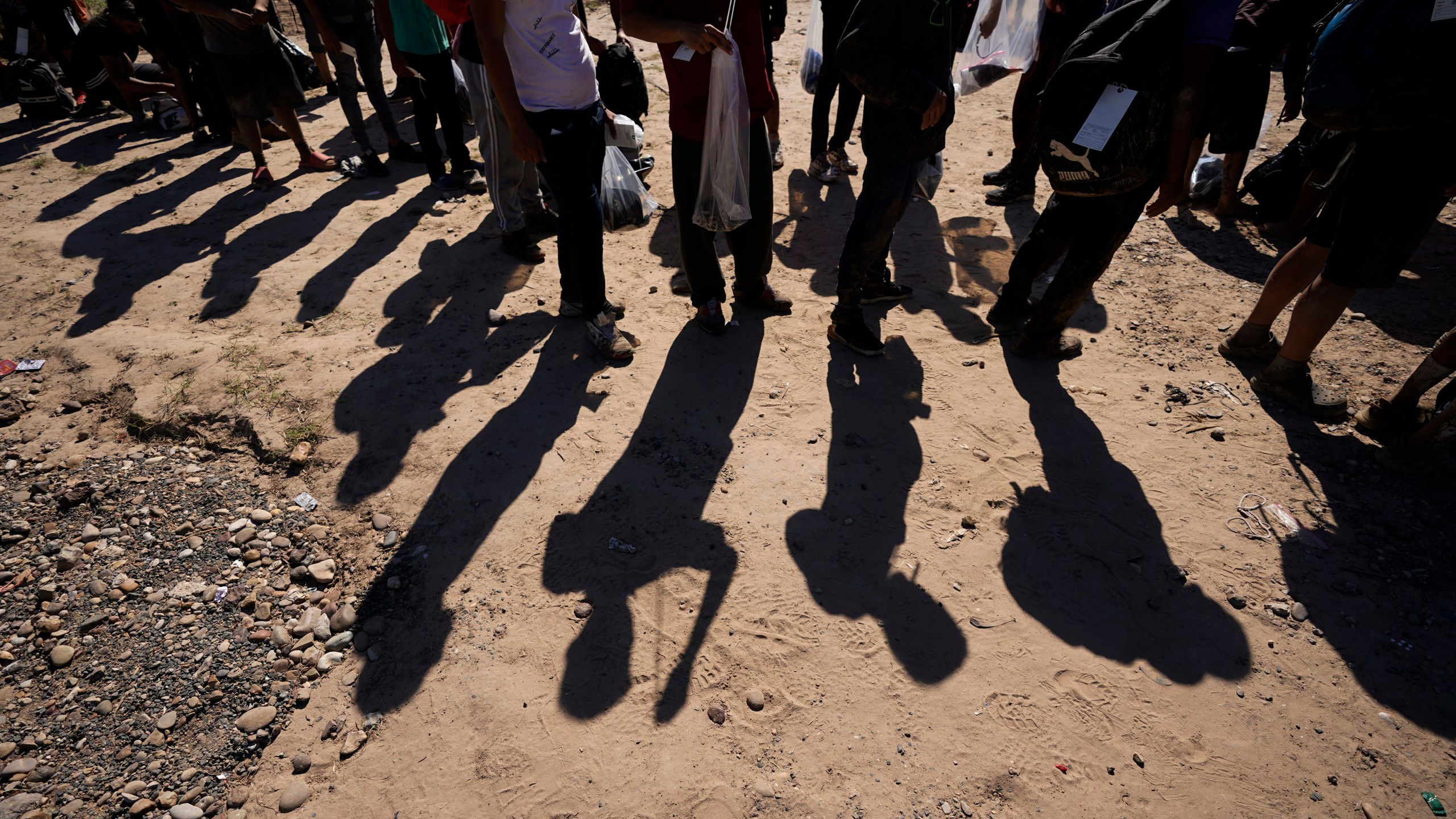 FILE - Migrants wait to be processed by the U.S. Customs and Border Patrol after they crossed the Rio Grande and entered the U.S. from Mexico, Oct. 19, 2023, in Eagle Pass, Texas. A divided Supreme Court on Tuesday, March 19, 2024, lifted a stay on a Texas law that gives police broad powers to arrest migrants suspected of crossing the border illegally, while a legal battle over immigration authority plays out. (AP Photo/Eric Gay, File)