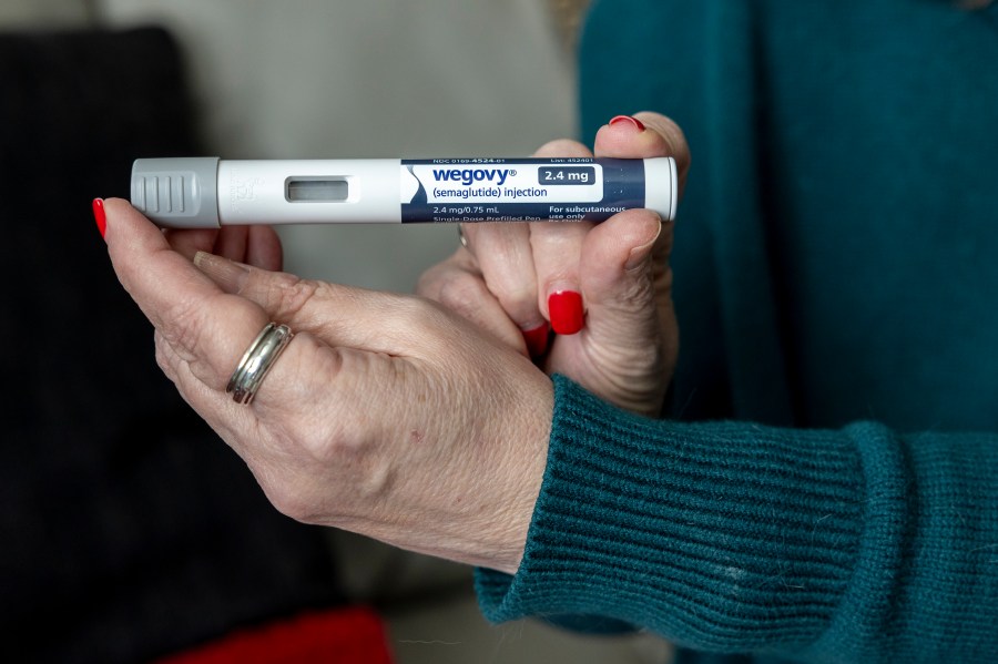 FILE - Donna Cooper holds up a dosage of Wegovy, a drug used for weight loss, at her home, March 1, 2024, in Front Royal, Va. The popular weight-loss drug Wegovy may be paid for by Medicare — as long as patients using it also have heart disease and need to reduce the risk of future heart attacks, strokes and other serious problems, federal officials said Thursday, March 21. (AP Photo/Amanda Andrade-Rhoades, File)