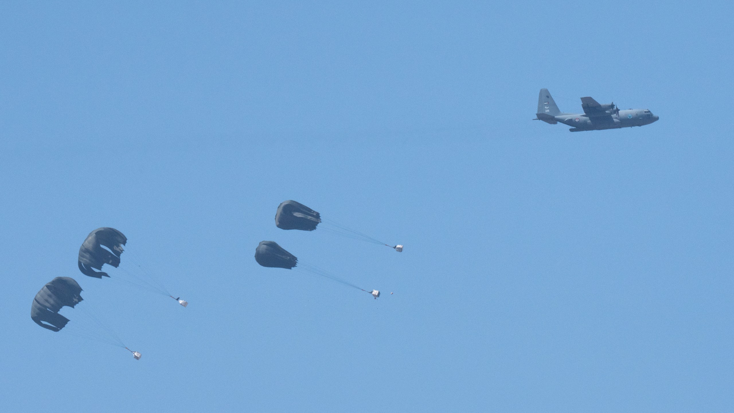 An aircraft airdrops humanitarian aid over northern Gaza Strip, as seen from southern Israel, Thursday, March 21, 2024. (AP Photo/Ohad Zwigenberg)