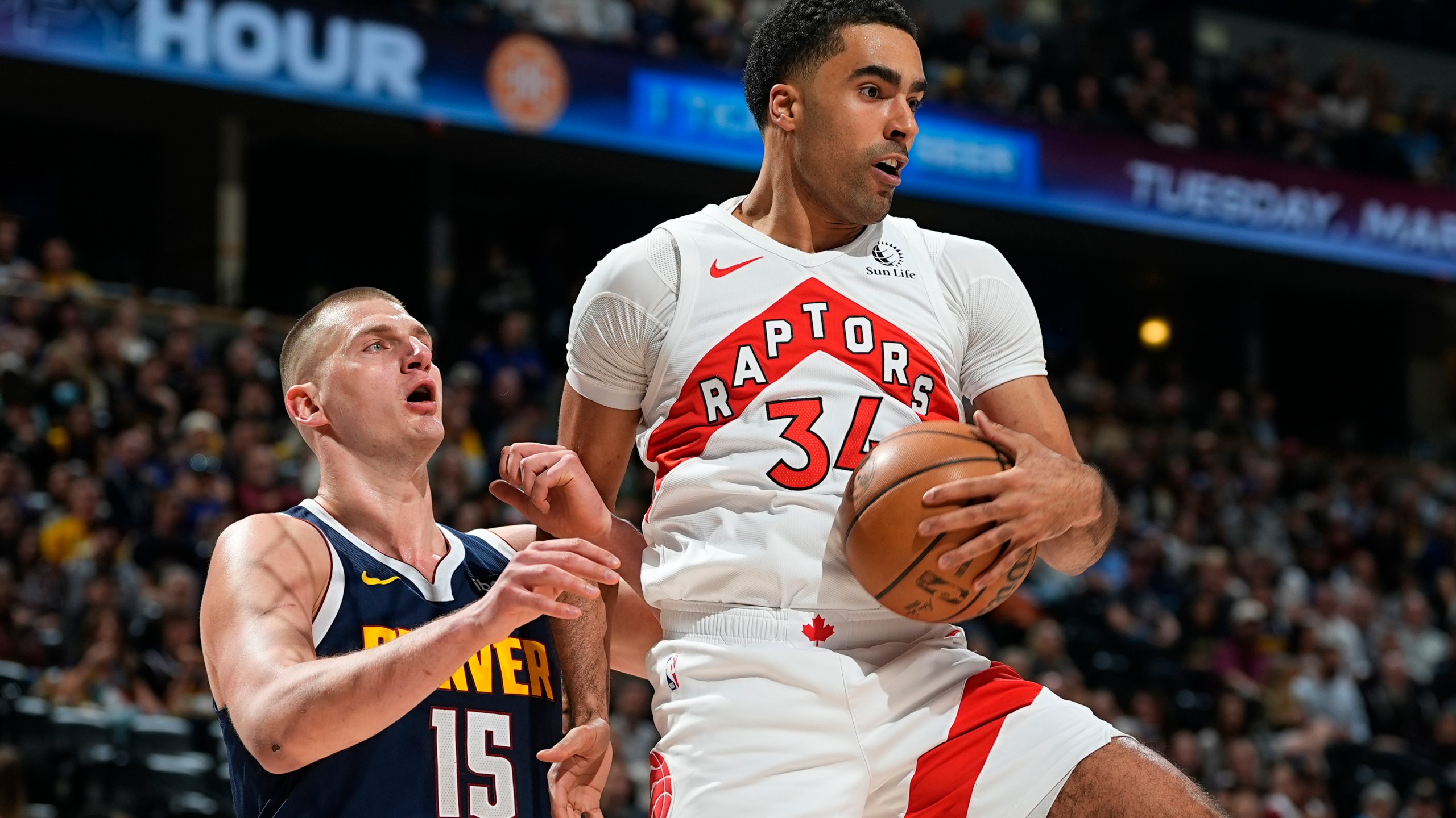 Toronto Raptors center Jontay Porter, right, pulls in a rebound as Denver Nuggets center Nikola Jokic, left, defends in the first half of an NBA basketball game Monday, March 11, 2024, in Denver. (AP Photo/David Zalubowski)