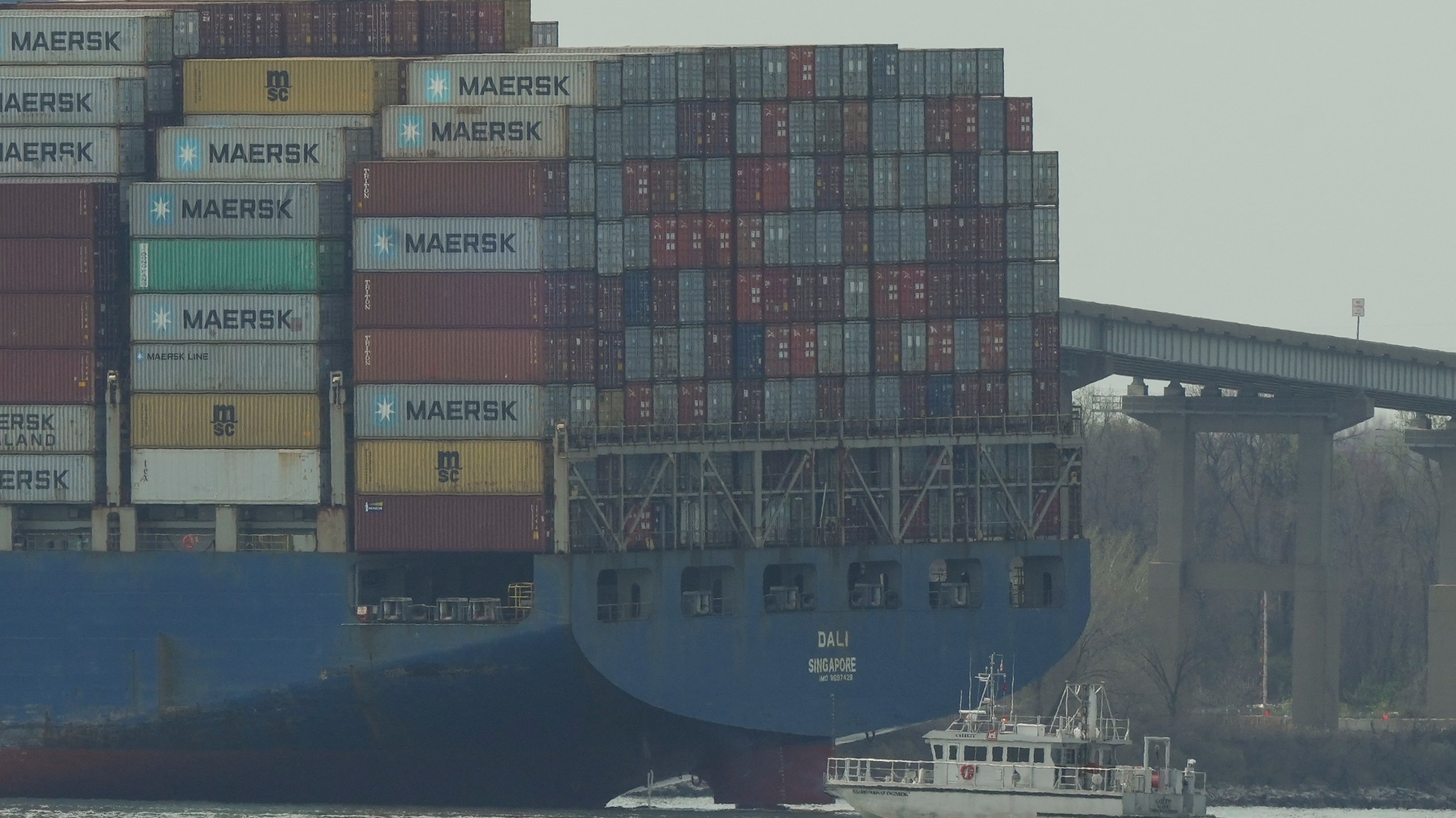 A container ship rests against wreckage of the Francis Scott Key Bridge on Tuesday, March 26, 2024, as seen from Dundalk, Md. The ship rammed into the major bridge in Baltimore early Tuesday, causing it to collapse in a matter of seconds and creating a terrifying scene as several vehicles plunged into the chilly river below. (AP Photo/Matt Rourke)