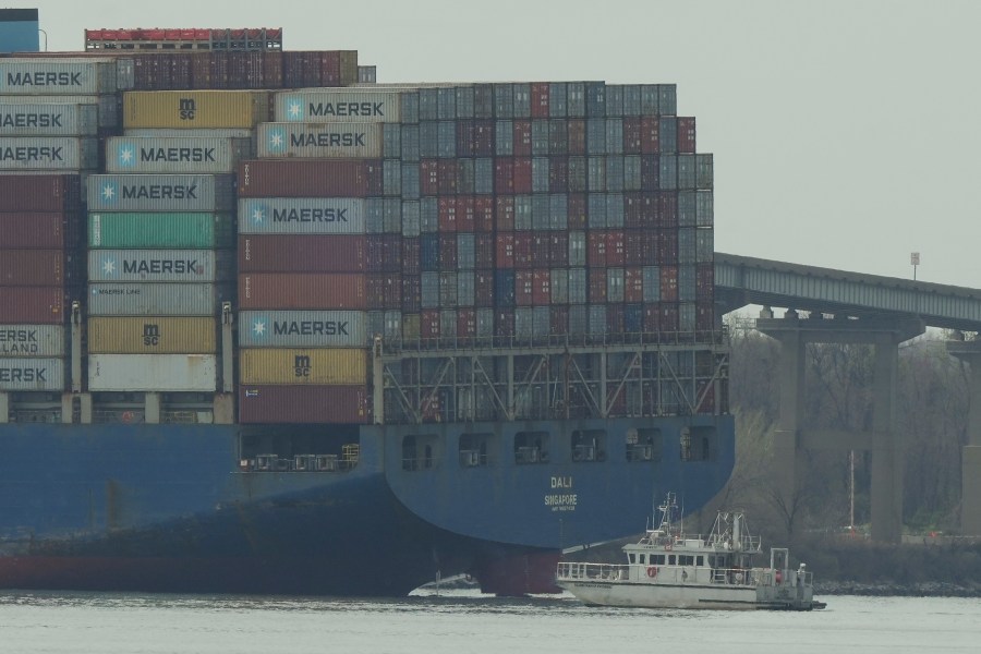 A container ship rests against wreckage of the Francis Scott Key Bridge on Tuesday, March 26, 2024, as seen from Dundalk, Md. The ship rammed into the major bridge in Baltimore early Tuesday, causing it to collapse in a matter of seconds and creating a terrifying scene as several vehicles plunged into the chilly river below. (AP Photo/Matt Rourke)