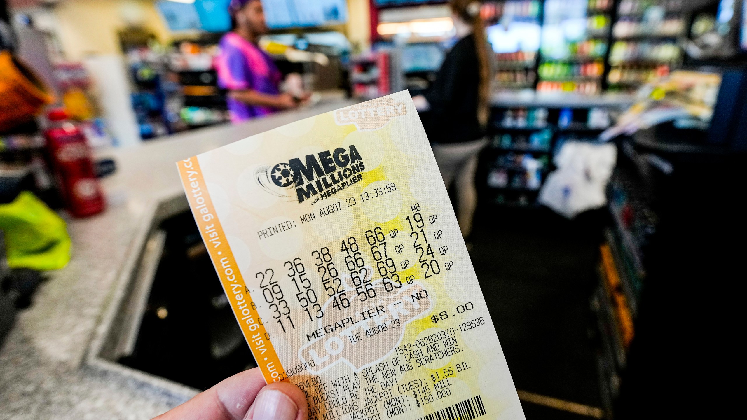 FILE - A Mega Millions ticket is seen as a person makes a purchase inside a convenience store, Aug. 7, 2023, in Kennesaw, Ga. Someone in New Jersey overcame the odds and won the $1.13 billion Mega Millions jackpot, breaking a winless streak that dated to last December. The numbers drawn Tuesday night, March 26, 2024, were: 7, 11, 22, 29, 38 and the gold Mega Ball 4. (AP Photo/Mike Stewart, File)