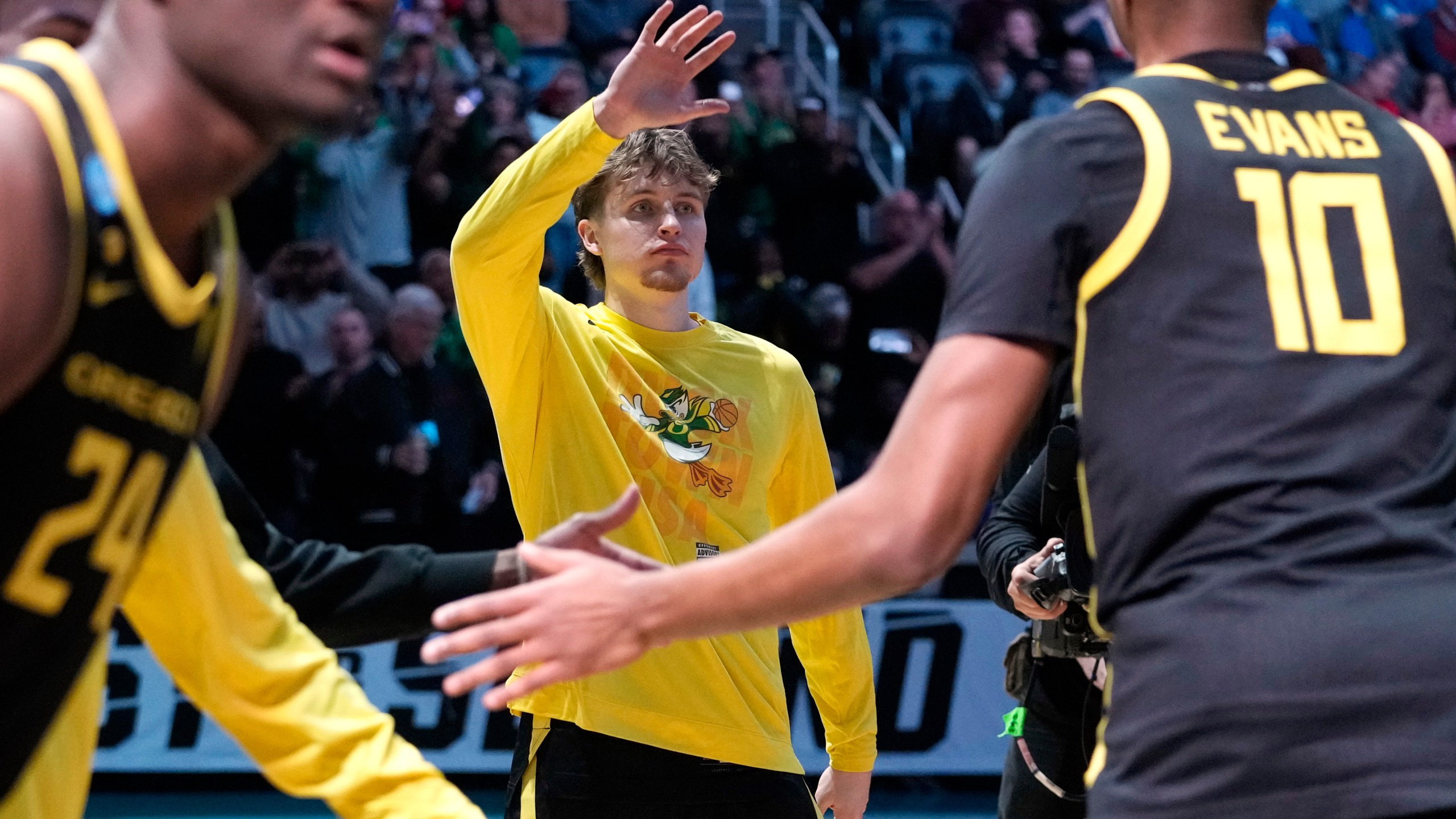 FILE- Oregon's Gabe Reichle, center, greets teammate Kwame Evans Jr. (10) as he is introduced before a college basketball game against Creighton in the second round of the NCAA men's tournament in Pittsburgh, Saturday, March 23, 2024. Reichle orchestrates the pregame handshake for his Oregon teammates. (AP Photo/Gene J. Puskar)