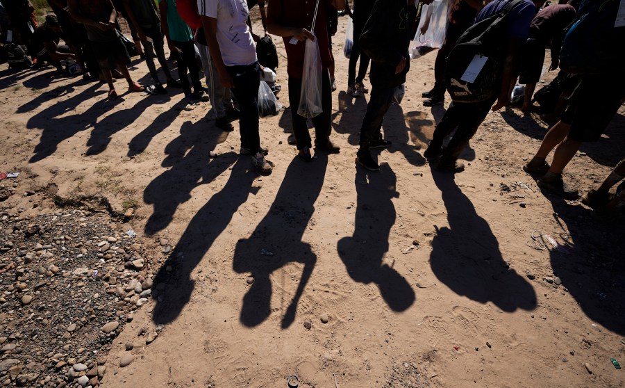 FILE - Migrants wait to be processed by the U.S. Customs and Border Patrol after they crossed the Rio Grande and entered the U.S. from Mexico, Oct. 19, 2023, in Eagle Pass, Texas. A Texas law that allows the state to arrest and deport migrants suspected of illegally entering the U.S. will remain on hold for now, a federal appeals court ruled. The order late Tuesday, March 26, 2024, from the 5th U.S. Circuit Court of Appeals followed a March 20 hearing by a three-judge panel of the court. It’s just the latest move in a seesaw legal case that is not yet over. (AP Photo/Eric Gay, File)