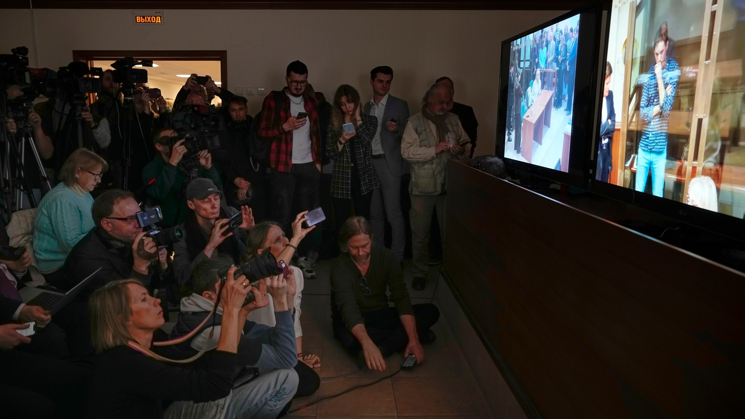 FILE - Journalists watch a televised court hearing on Wall Street Journal reporter Evan Gershkovich in Moscow, Russia, on Tuesday, April 18, 2023. Gershkovich is a U.S. citizen and has been jailed in Russia for a year on charges of espionage, which he, his employer and the U.S. government all deny. (AP Photo/Alexander Zemlianichenko, File)