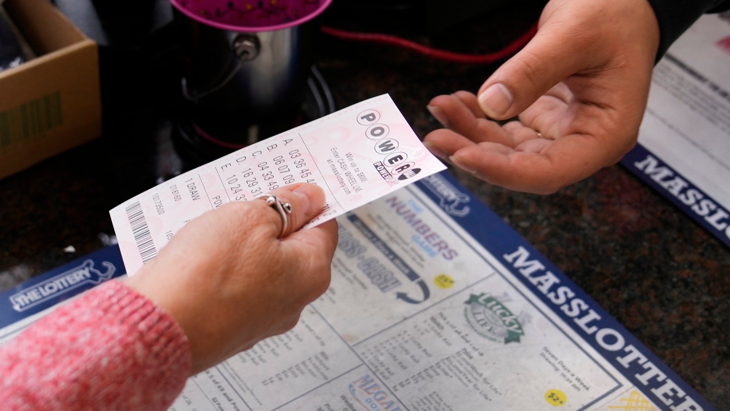 FILE - A customer purchases five Powerball tickets at a lottery agent, Tuesday, Oct. 10, 2023, in Haverhill, Mass. (AP Photo/Charles Krupa, File)