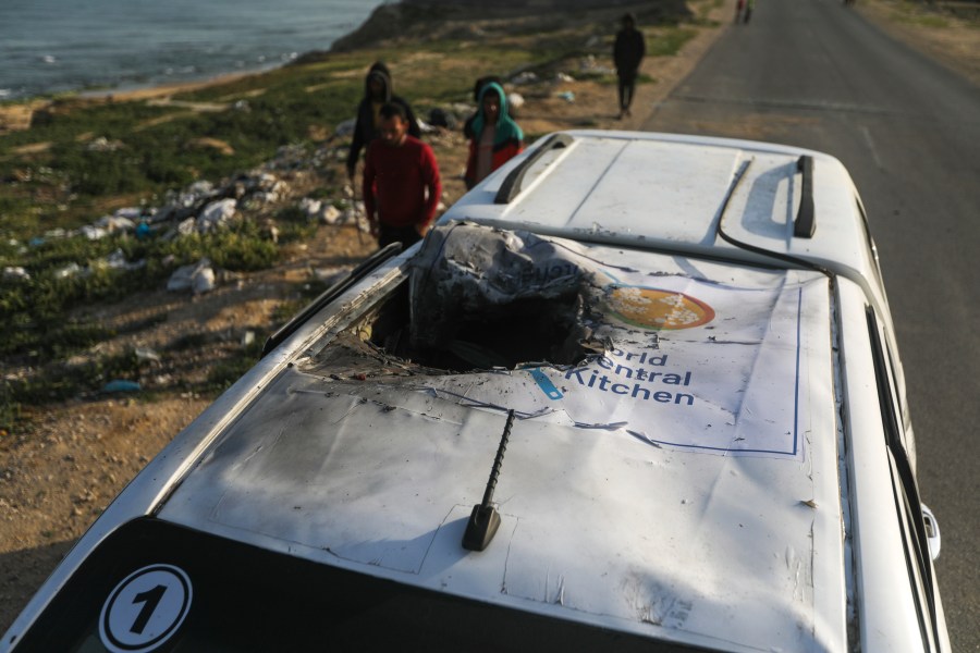 Palestinians inspect a vehicle with the logo of the World Central Kitchen wrecked by an Israeli airstrike in Deir al Balah, Gaza Strip, Tuesday, April 2, 2024. A series of airstrikes killed seven aid workers from the international charity, leading it to suspend delivery Tuesday of vital food aid to Gaza. (AP Photo/Ismael Abu Dayyah)