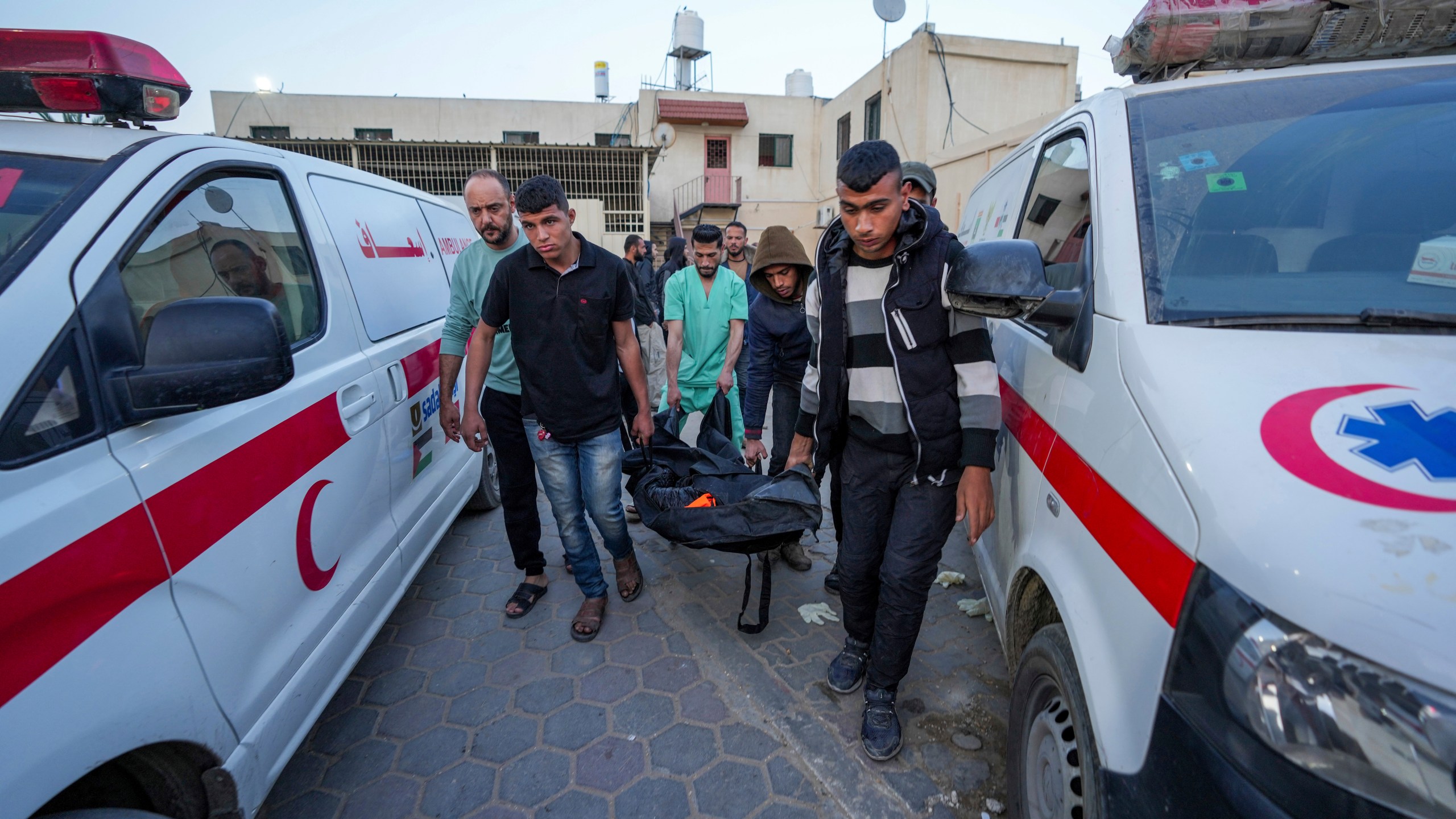 FILE - Palestinians carry the body of a World Central Kitchen worker at Al Aqsa hospital in Deir al-Balah, Gaza Strip on April 2, 2024. In Israel's drive to destroy Hamas, the rights groups and workers say Israel seems to have given itself wide leeway to determine what is a target and how many civilian deaths it allows as collateral damage. Israel says it's targeting Hamas and blames the civilian death toll on militants operating among the population. (AP Photo/Abdel Kareem Hana)