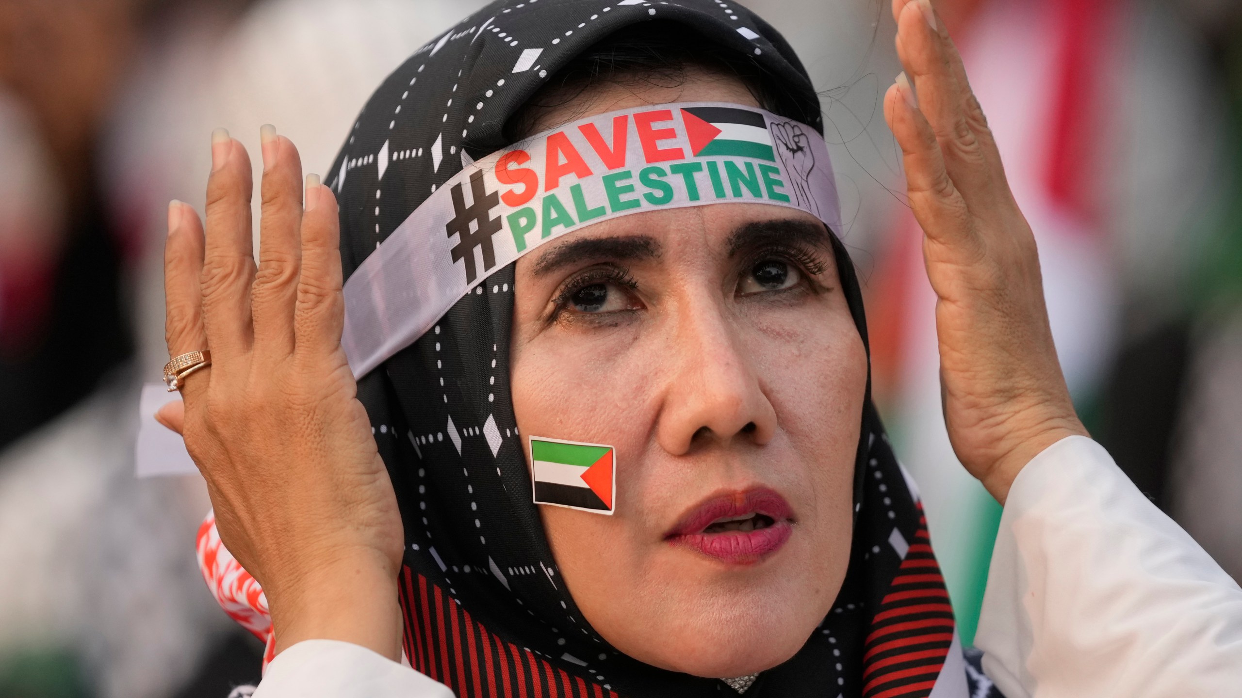 A protester adjusts her headband during a rally and prayer in support of the Palestinians in Gaza, in Jakarta, Indonesia, Sunday, April 7, 2024. (AP Photo/Dita Alangkara)