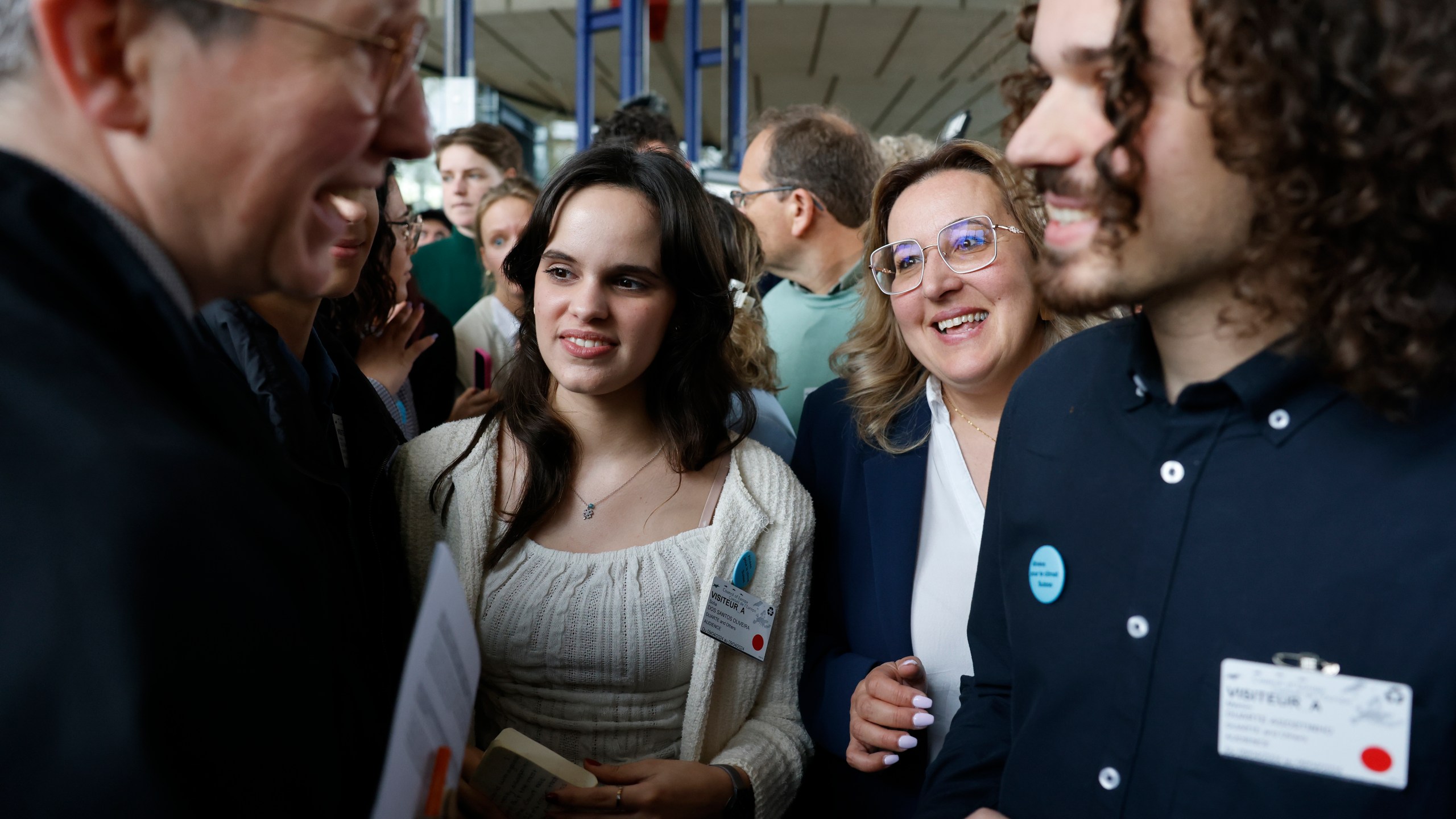 Portugal's Sofia Dos Santos Oliveira, center left, smiles after the European Court of Human Rights' ruling, Tuesday, April 9, 2024 in Strasbourg, eastern France. Europe's highest human rights court ruled that its member nations have an obligation to protect their citizens from the ill effects of climate change, but still threw out a high-profile case brought by six Portuguese youngsters aimed at forcing countries to reduce greenhouse gas emissions. (AP Photo/Jean-Francois Badias)