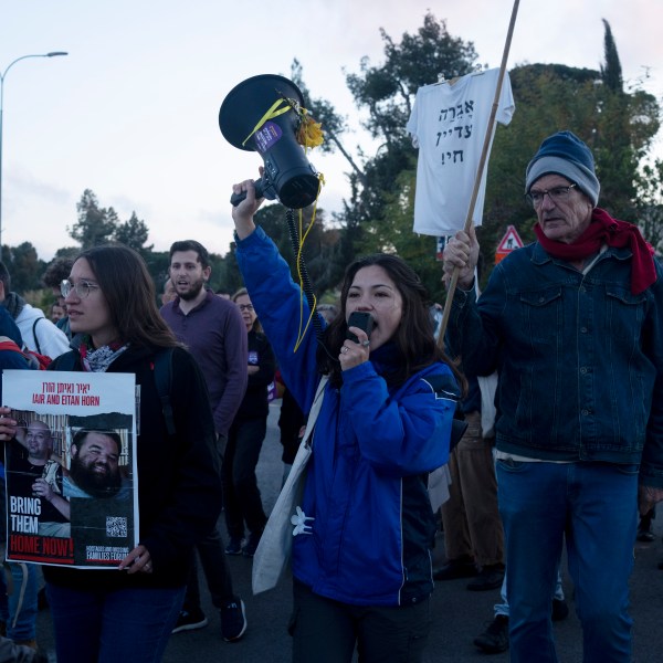 Relatives of hostages held in Gaza and their supporters move into an intersection to protest outside of the Prime Minister's office to call for an immediate release of the captives for the Jewish holiday of Passover as the war cabinet meets in Jerusalem, Tuesday, April 9, 2024. (AP Photo/Maya Alleruzzo)