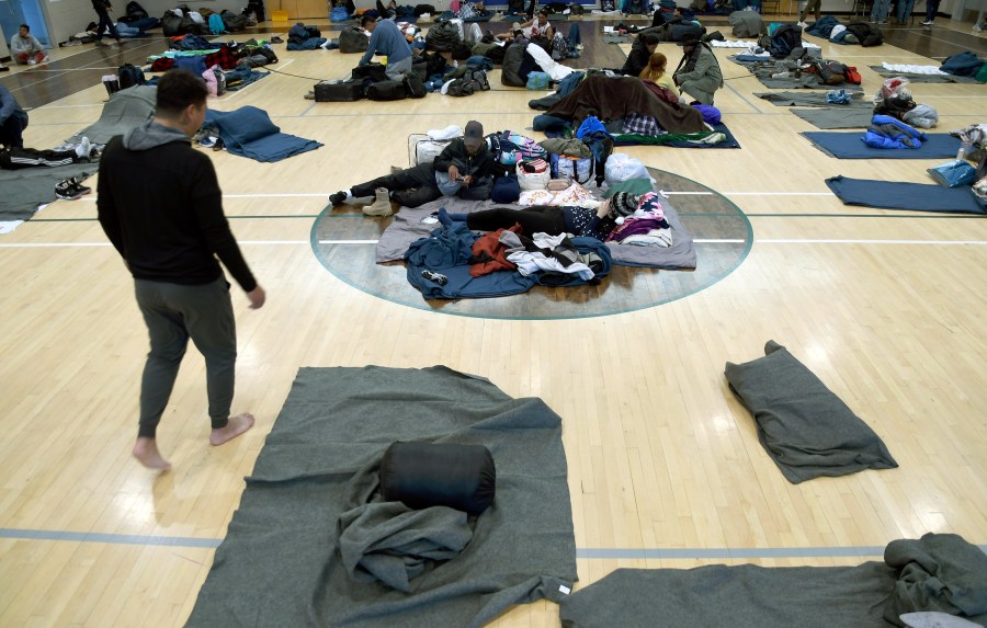 FILE - Migrants rest at a makeshift shelter, Jan. 6, 2023, in Denver. Denver Mayor Mike Johnston announced a major shift Wednesday, April 10, 2024, in the city's response to the migrant crisis, extending support to six months but with only 1,000 spaces. The mayor's pivot follows failed attempts to get federal aid and deep cuts to the city's budget as Denver served nearly 41,000 migrants since the end of 2022. (AP Photo/Thomas Peipert, File)