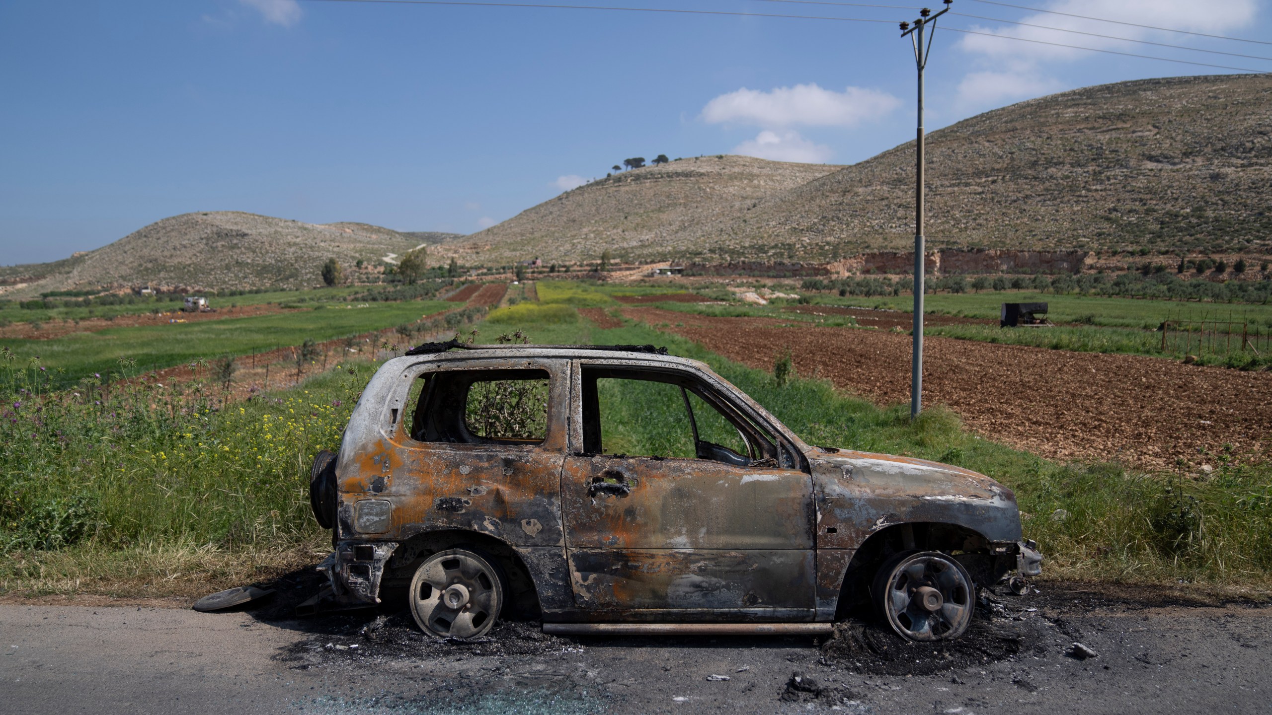 A torched vehicle is seen in the West Bank village of al-Mughayyir, Saturday, April 13, 2024. Dozens of Israeli settlers stormed into a Palestinian village in the Israeli-occupied West Bank on Friday, shooting and setting houses and cars on fire. The rampage killed a Palestinian man and wounded 25 others, Palestinian health officials said. An Israeli rights group said the settlers were searching for a missing 14-year-old boy from their settlement. (AP Photo/Nasser Nasser)