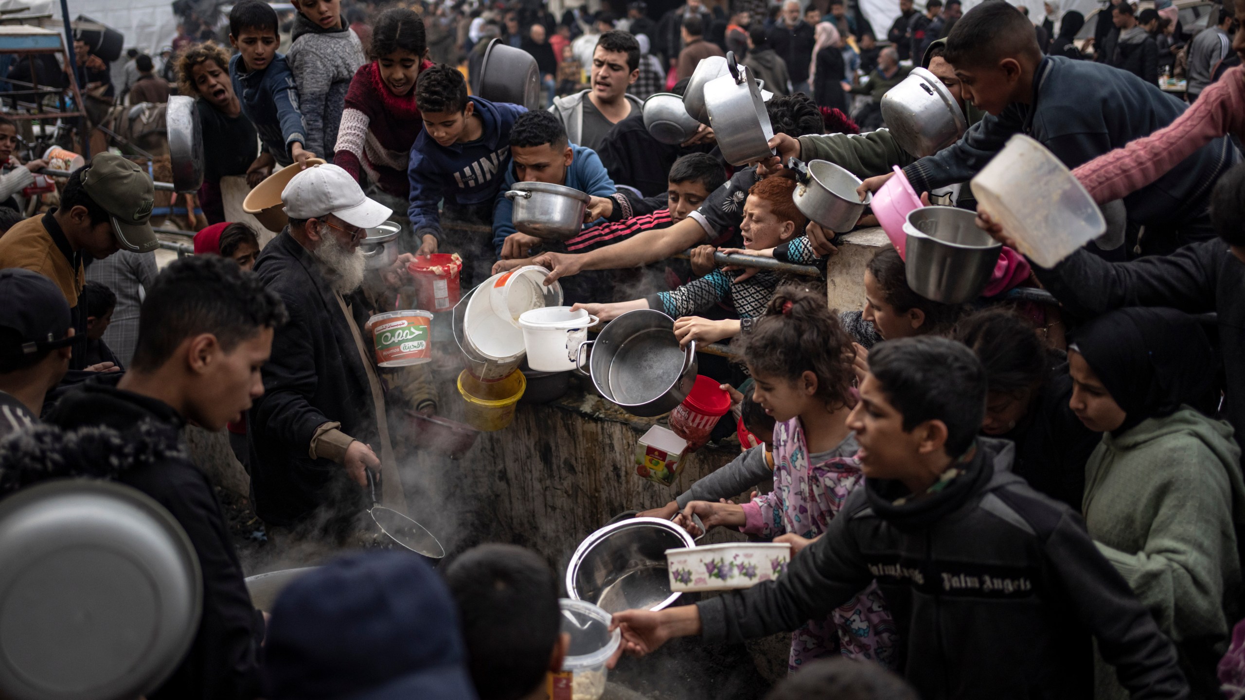 FILE - Palestinians line up for a meal in Rafah, Gaza Strip, Thursday, Dec. 21, 2023. The United Nations appealed for $2.8 billion on Tuesday, April 17, 2024, to provide desperately needed aid to 3 million Palestinians, stressing that tackling looming famine in war-torn Gaza requires not only food but sanitation, water and health facilities. (AP Photo/Fatima Shbair, File)