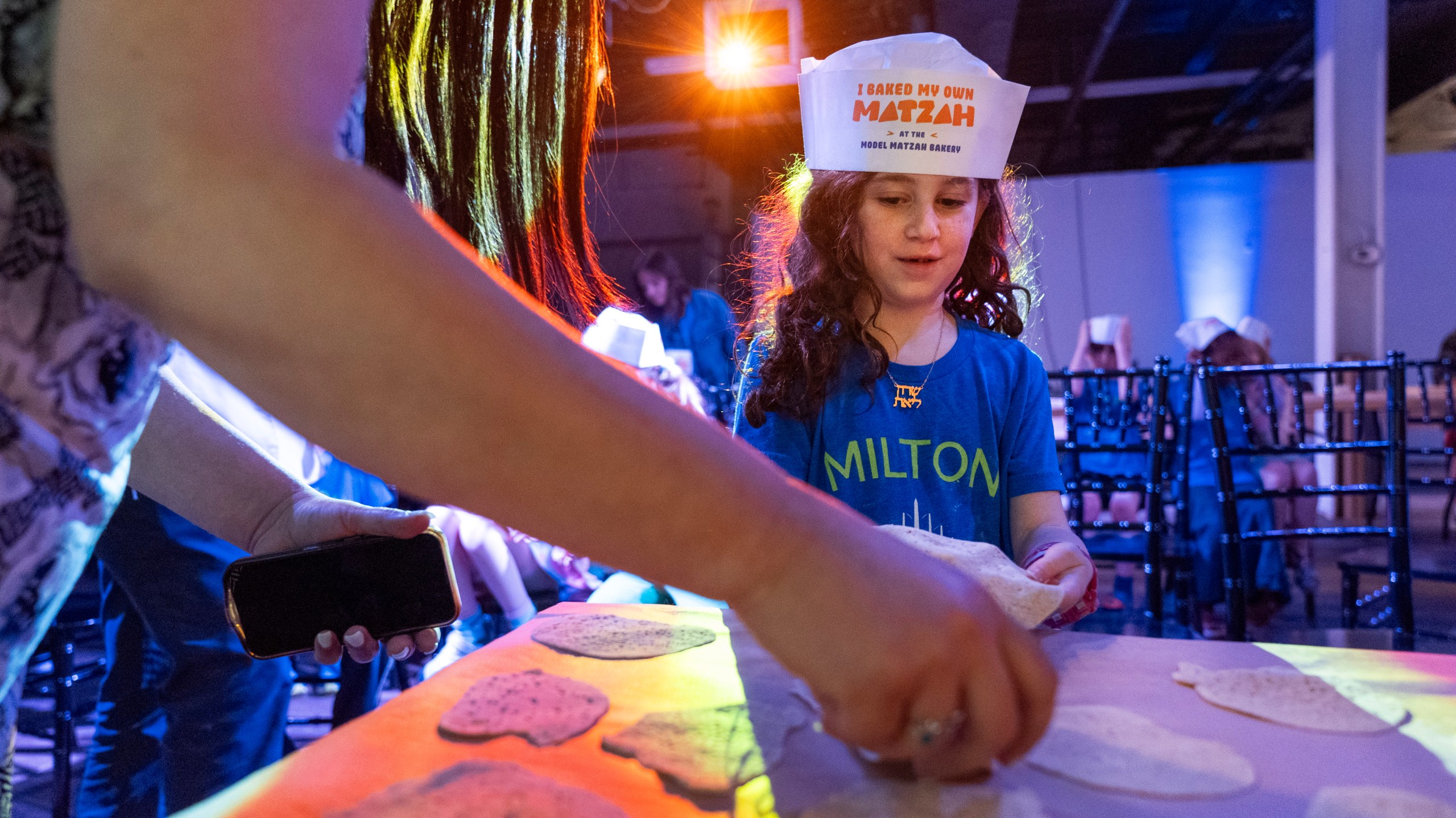 Charlotte Gleicher, 7, a first grader at Milton Gottesman Jewish Day School of the Nation's Capital, brings up dough to be baked into matzah that she made during a "Matzah Factory" event at the JCrafts Center for Jewish Life and Tradition in Rockville, Md., Thursday, April 18, 2024, ahead of the Passover holiday which begins next Monday evening. To be kosher for Passover, which begins next Monday evening, the dough has to be prepared and cooked all within 18 minutes and not allowed to rise. (AP Photo/Jacquelyn Martin)