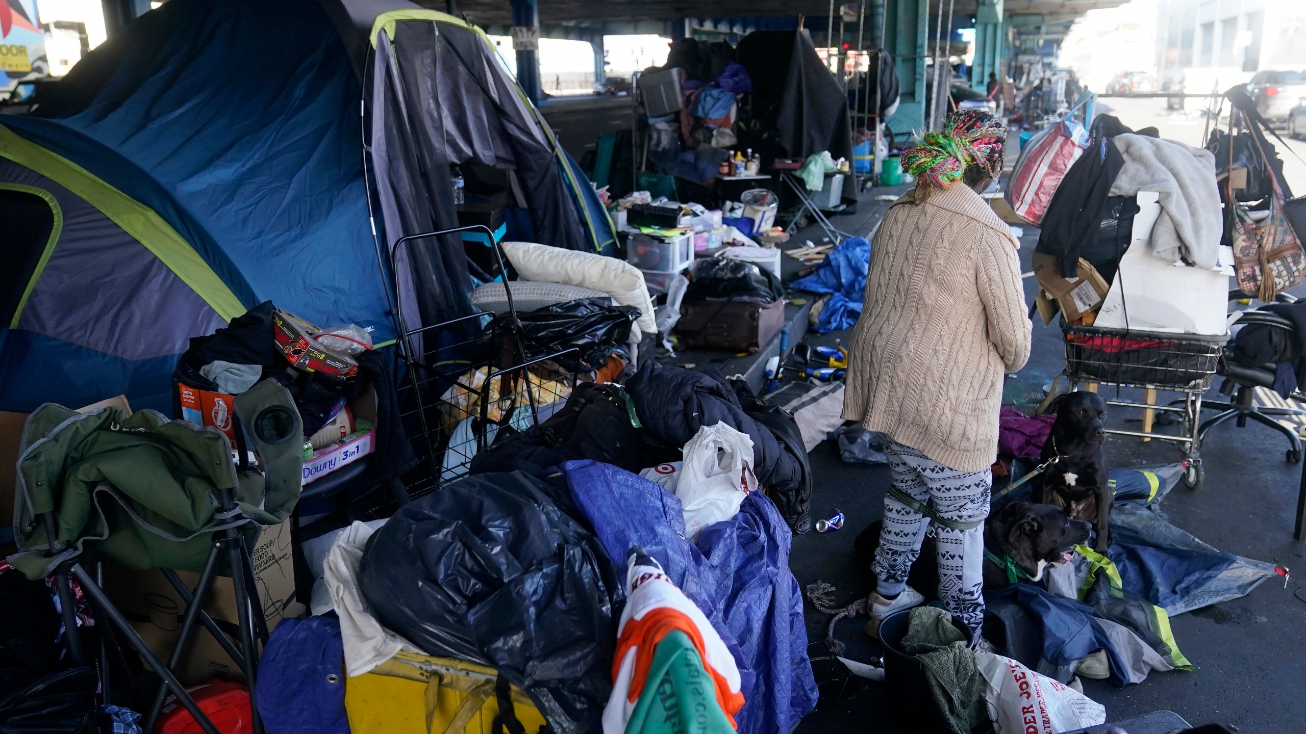 FILE - A woman gathers possessions to take before a homeless encampment was cleaned up in San Francisco, Aug. 29, 2023. The Supreme Court will hear its most significant case on homelessness in decades Monday, April 22, 2024, as record numbers of people in America are without a permanent place to live. The justices will consider a challenge to rulings from a California-based federal appeals court that found punishing people for sleeping outside when shelter space is lacking amounts to unconstitutional cruel and unusual punishment. (AP Photo/Jeff Chiu, File)